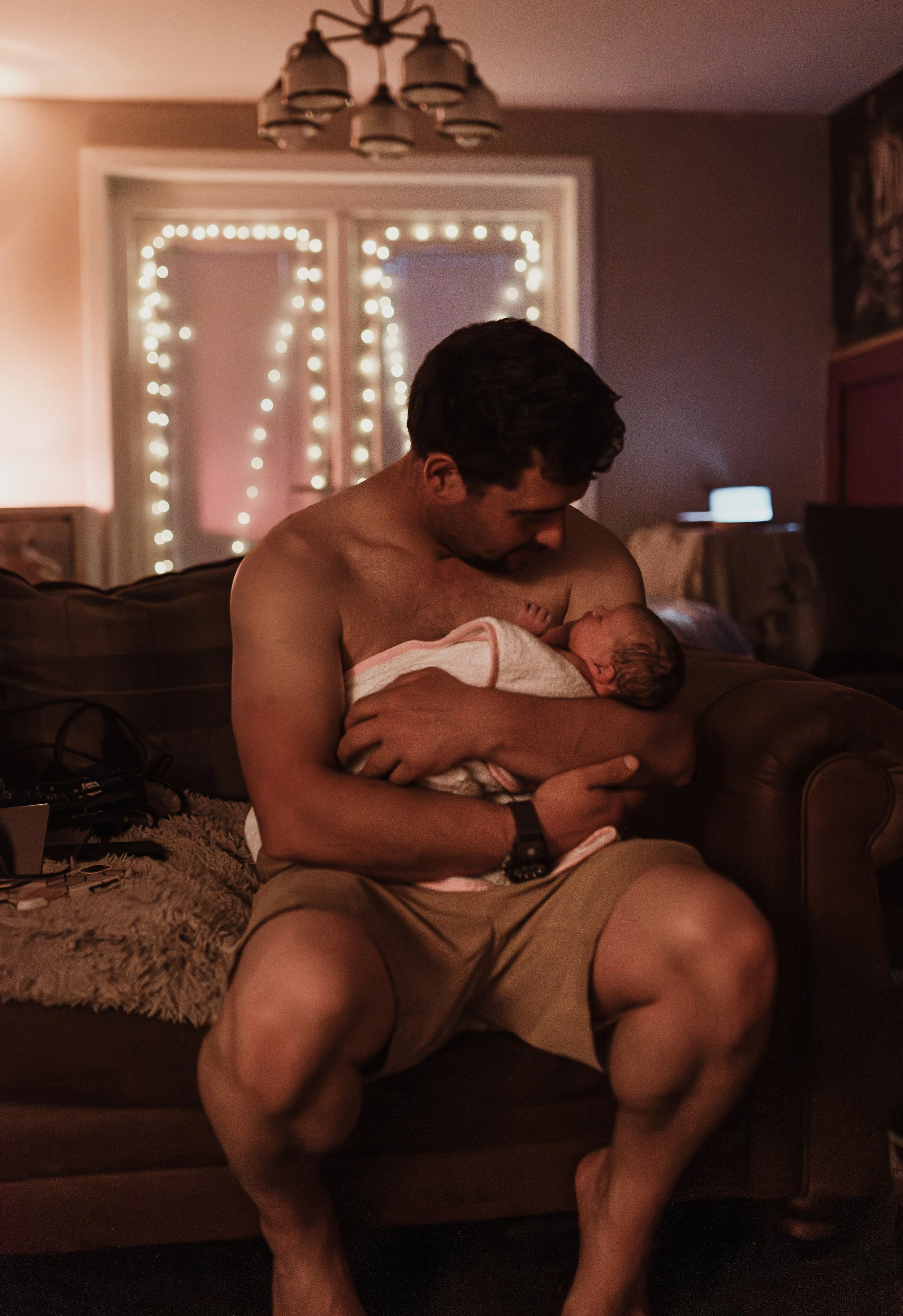 Father holding newborn in warm light at home after birth, Glasgow — birth photography by Marieke Captures Birth