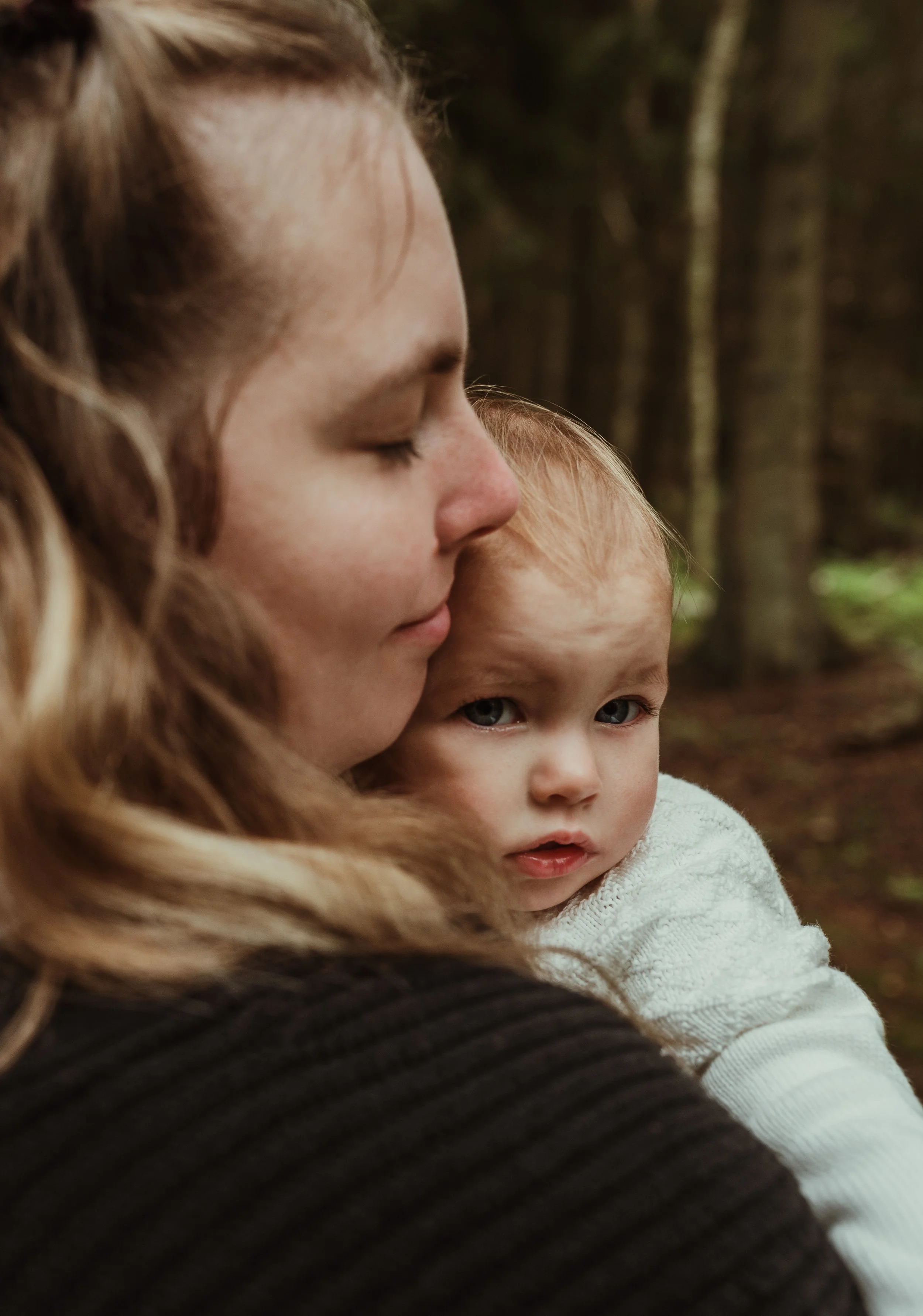 Mother and toddler sharing a tender forehead to forehead moment during a nursing photography session in Scotland with Marieke Captures Birth
