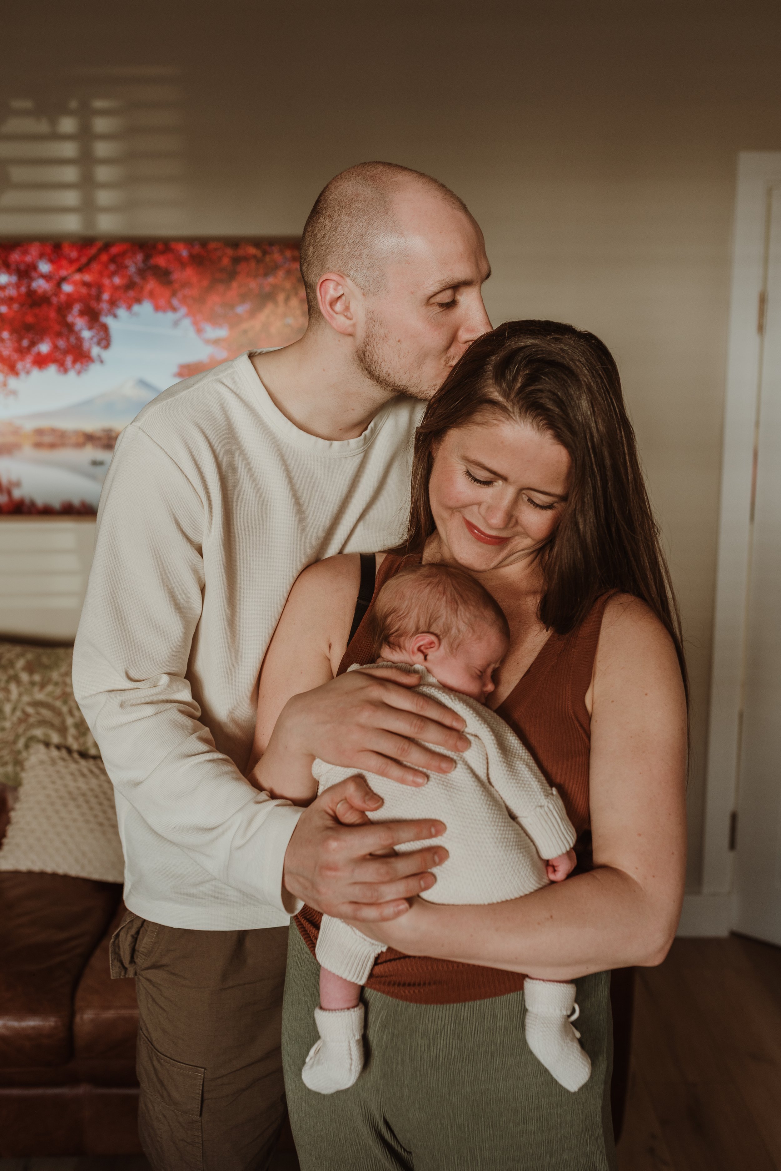 Newborn baby being held gently at home during unhurried newborn photography session in Glasgow