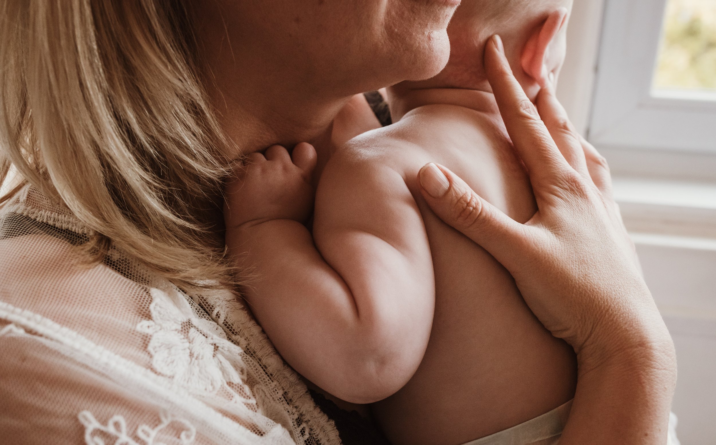 Mother nursing her newborn skin to skin in the early days at home during a newborn photography session with Glasgow photographer Marieke Captures Birth