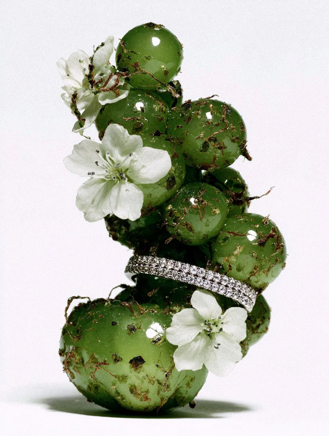 Porträt einer Person mit weißer Maske, die mit bunten Blumen- und Schmetterling-Motiven bemalt ist.
