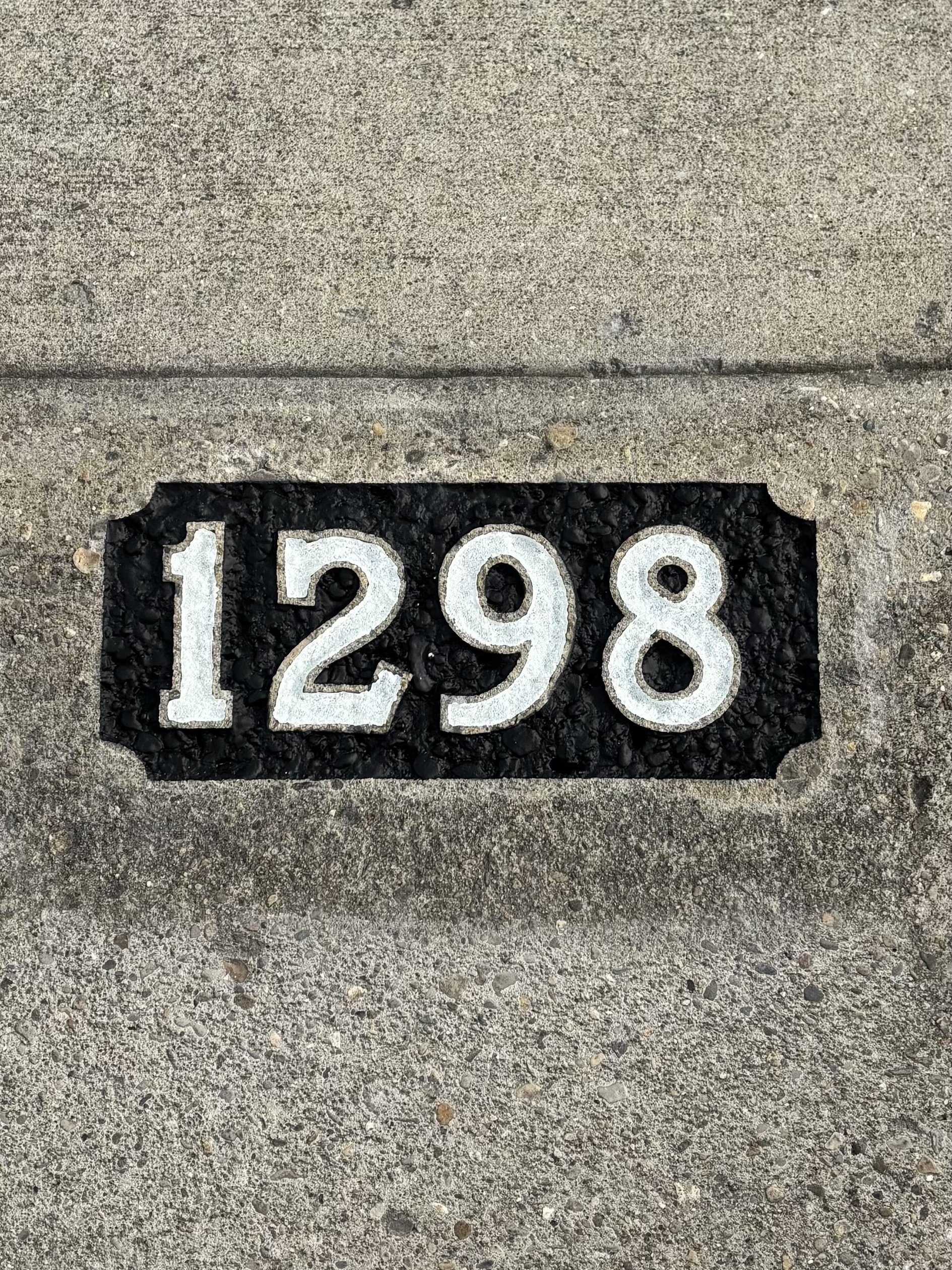   Image of completed reflective curb numbers, featuring a bright white finish designed for nighttime visibility and first responder navigation.