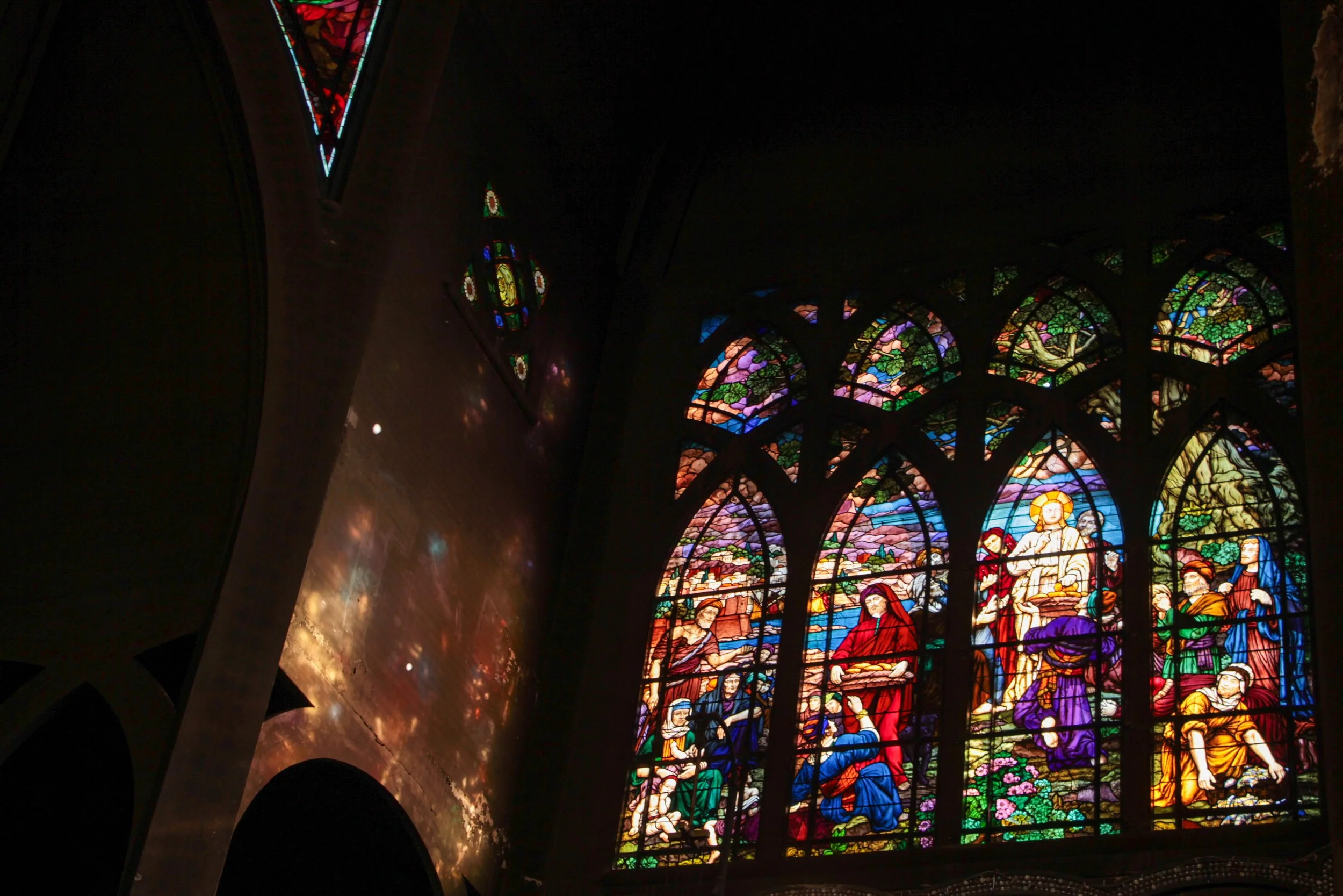 Colorful stained glass window depicting a religious scene in a church.