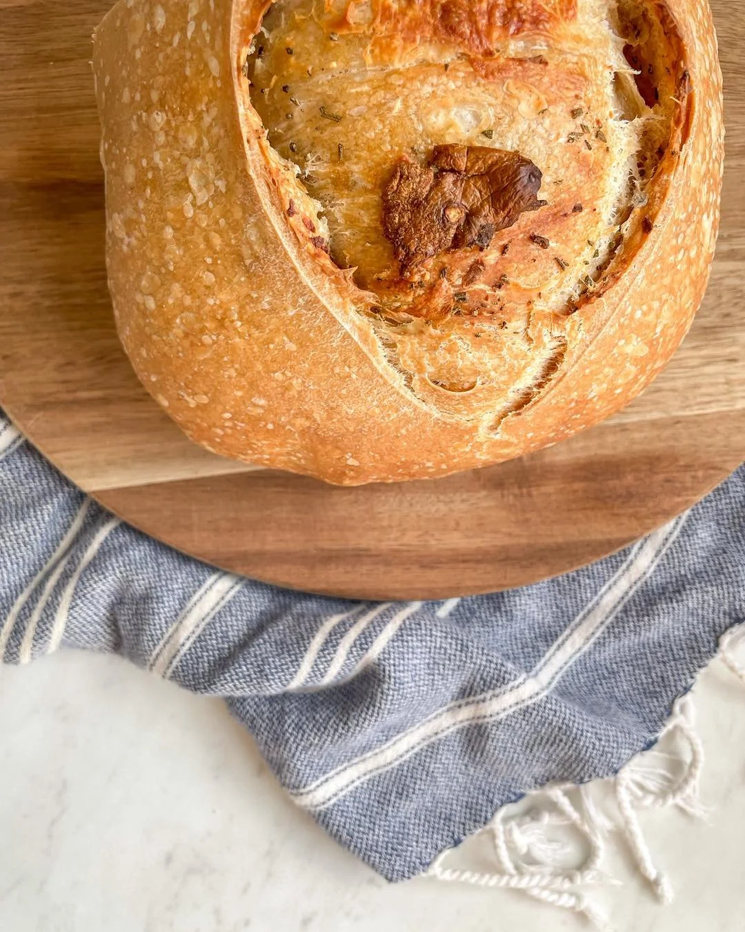 Roasted Garlic Parmesan Sourdough 🧄🧀
Slow roasted garlic folded into a soft, fluffy loaf with a sprinkle of rosemary, freshly cracked black pepper, and real Parmesan cheese (no anti caking agents - IYKYK). 
It&rsquo;s savory, aromatic, and just beg