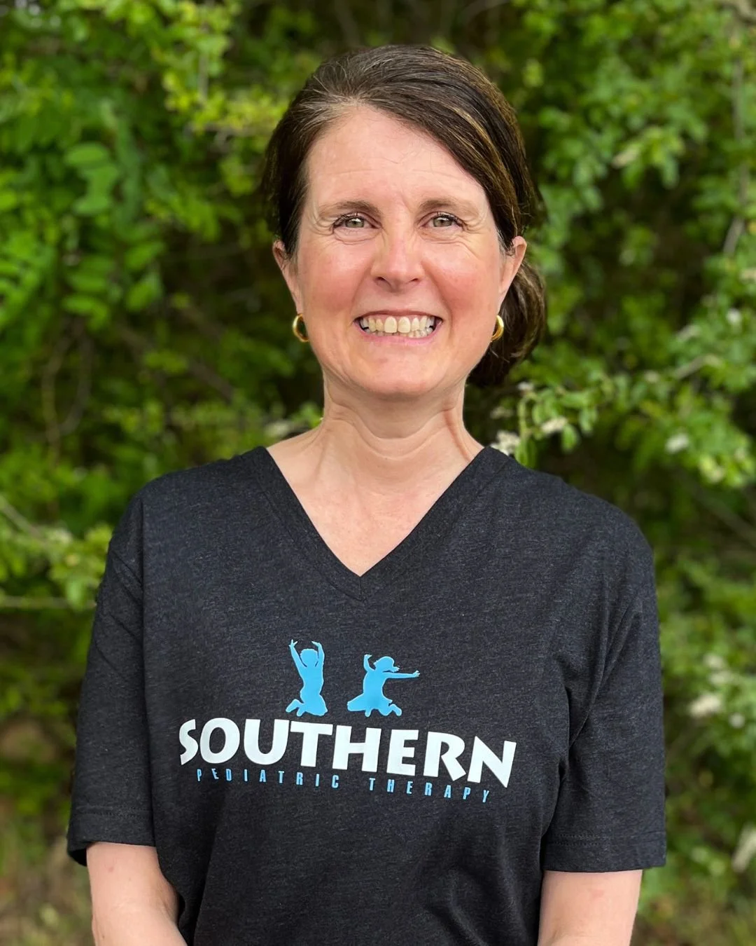 Smiling woman with Southern Pediatric Therapy shirts