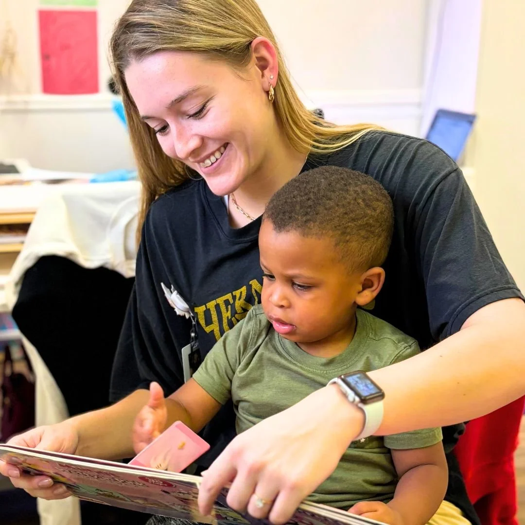 Therapist and child reading a book and smiling during occupation therapy at Southern Pediatric Therapy