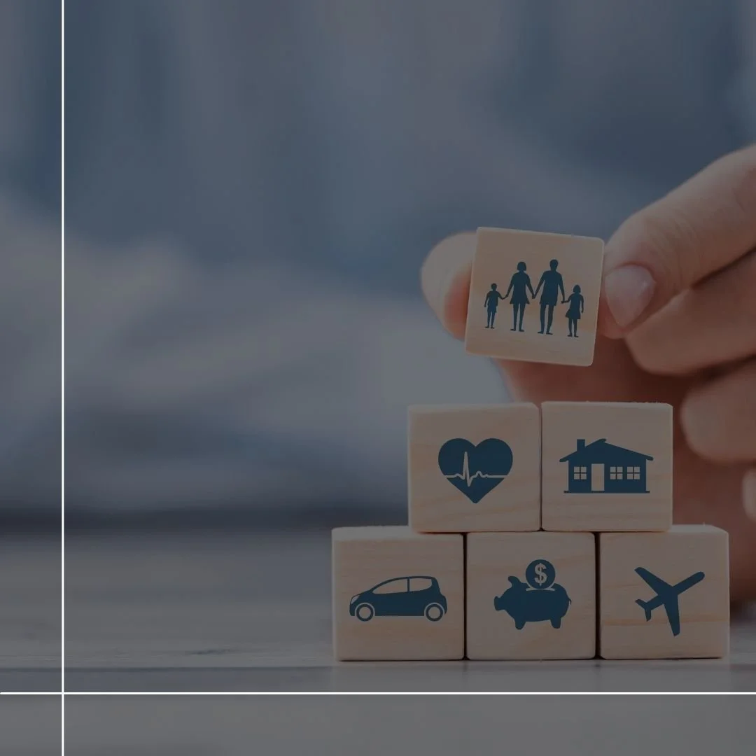 Hand stacking wooden blocks with family, healthcare, home, car, piggy bank, and travel icons.