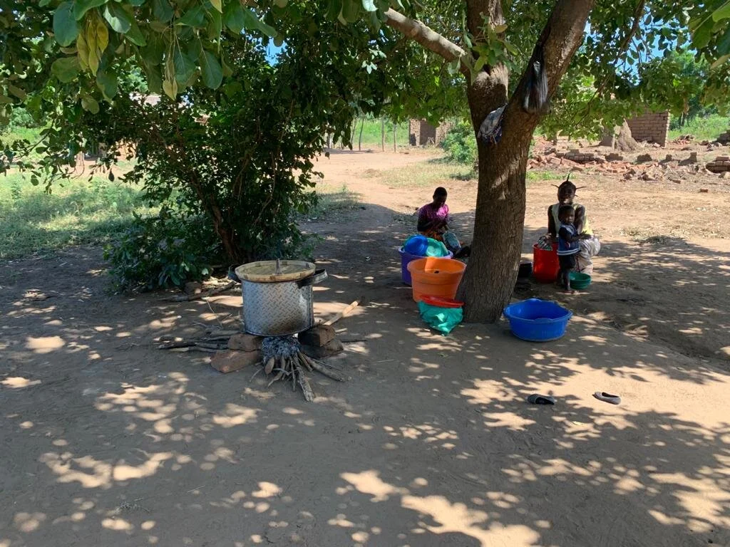 Volunteer cooking mothers busy making the daily porridge.