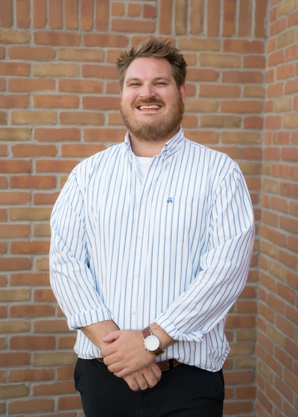 Michael Zandstra, therapist in Grand Rapids, smiling in front of a brick wall