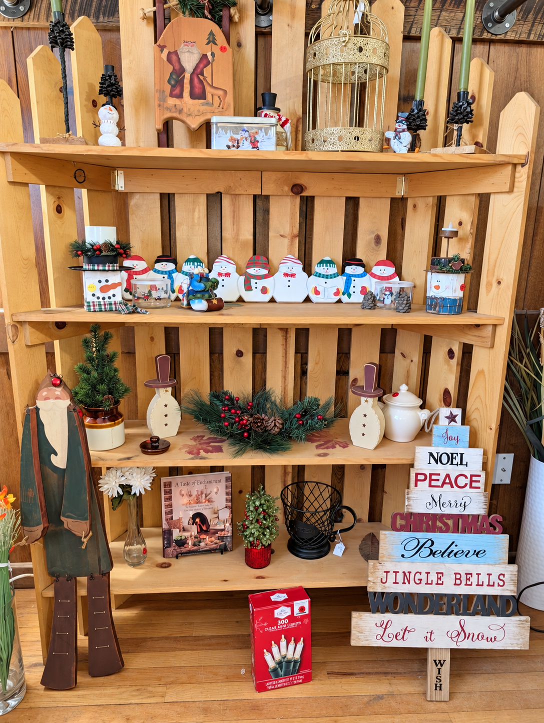 Snowmen and Christmas decorations on wooden display shelves at ECCO