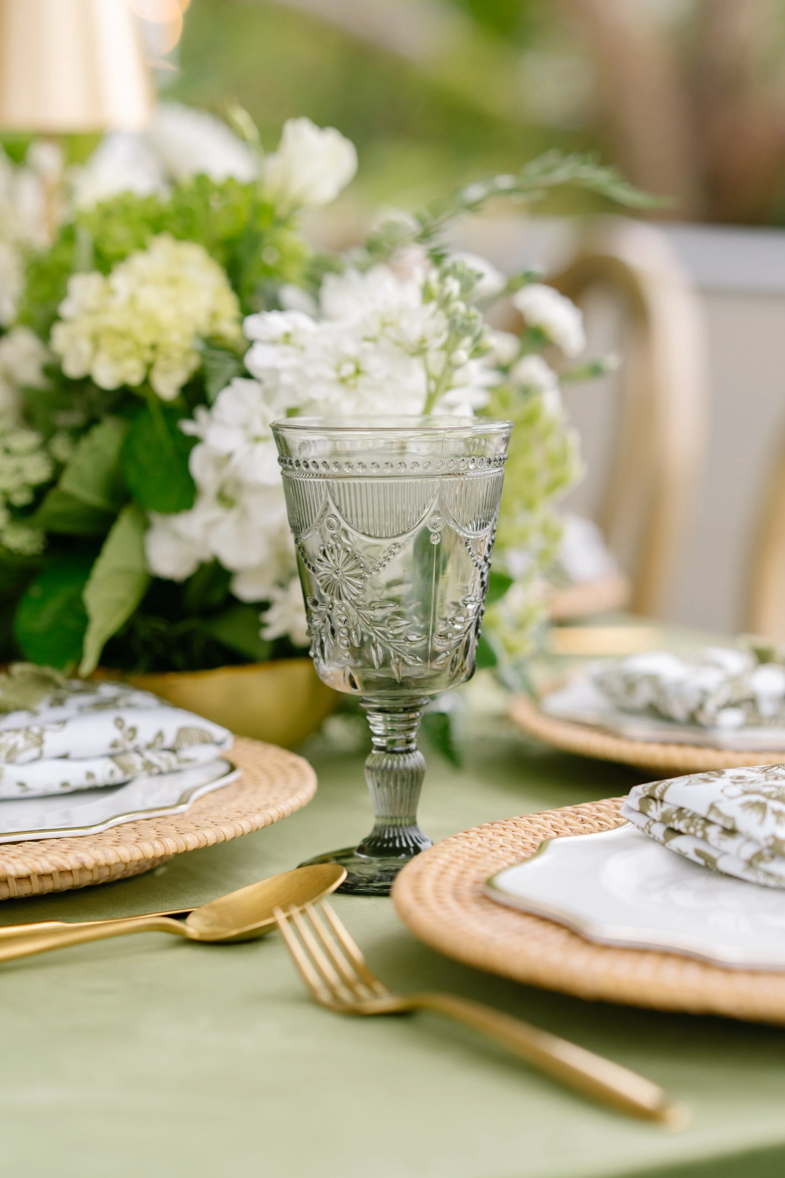 Elegant place setting with vintage etched glassware, gold flatware, and white floral centerpiece, Charleston SC wedding photographer