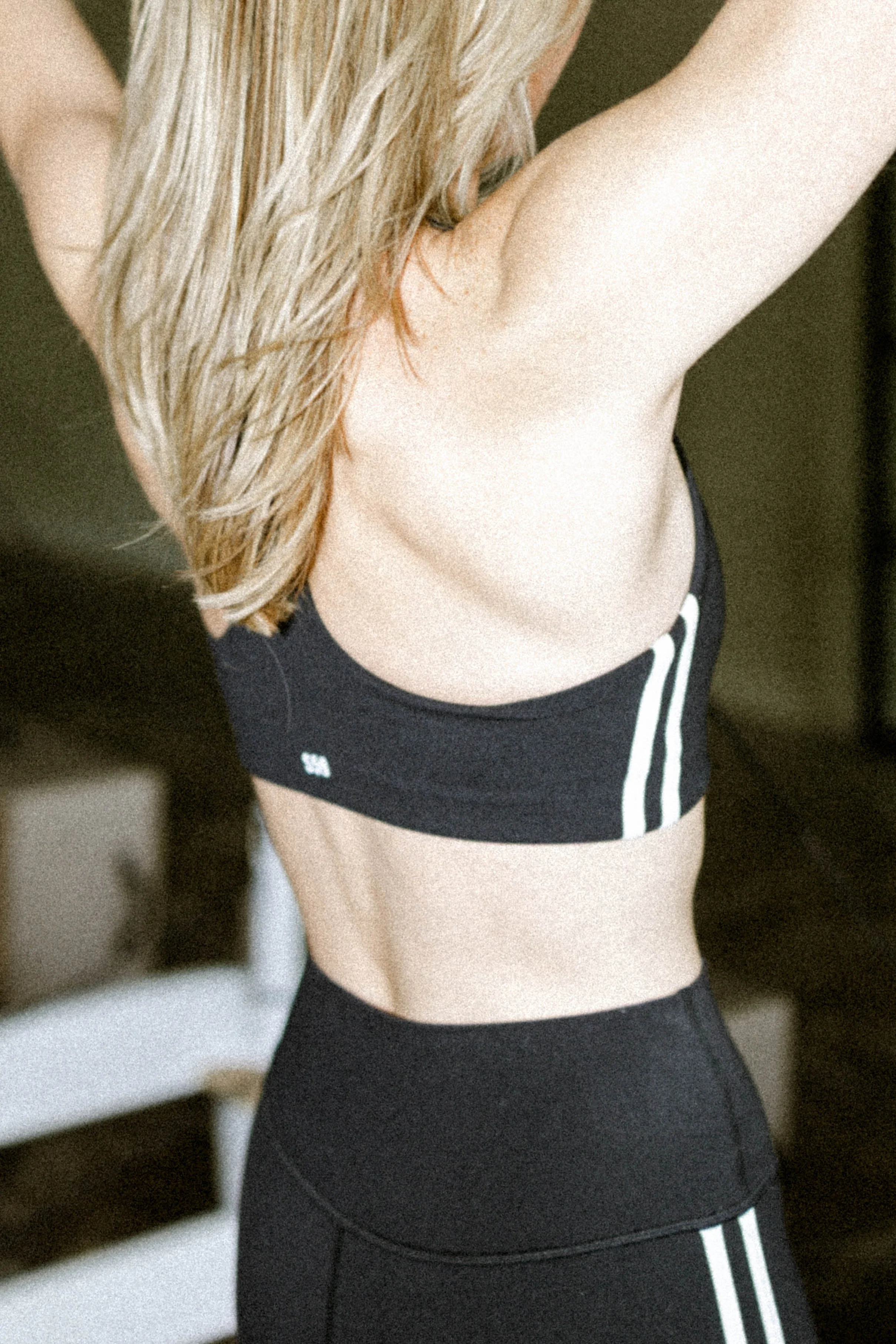 Close-up detail shot of a woman in a black sports bra with white stripe — commercial activewear photography by Chandler Cox, Columbia, SC