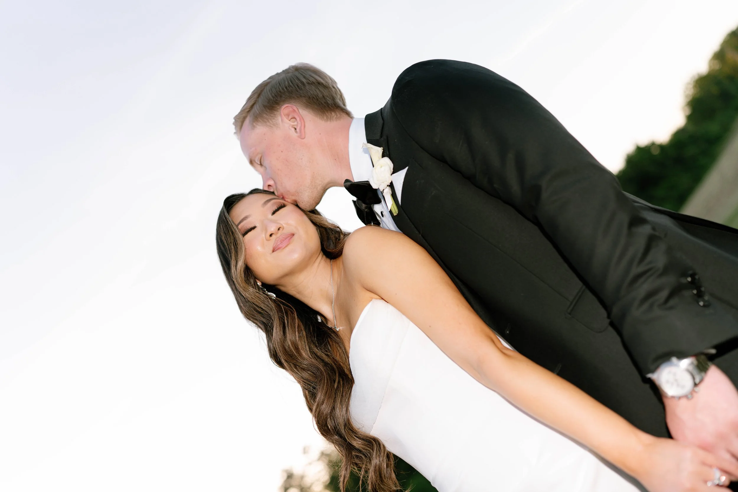 Groom kissing bride on the forehead during romantic wedding portraits, photographed by Chandler Cox Columbia SC wedding photographer