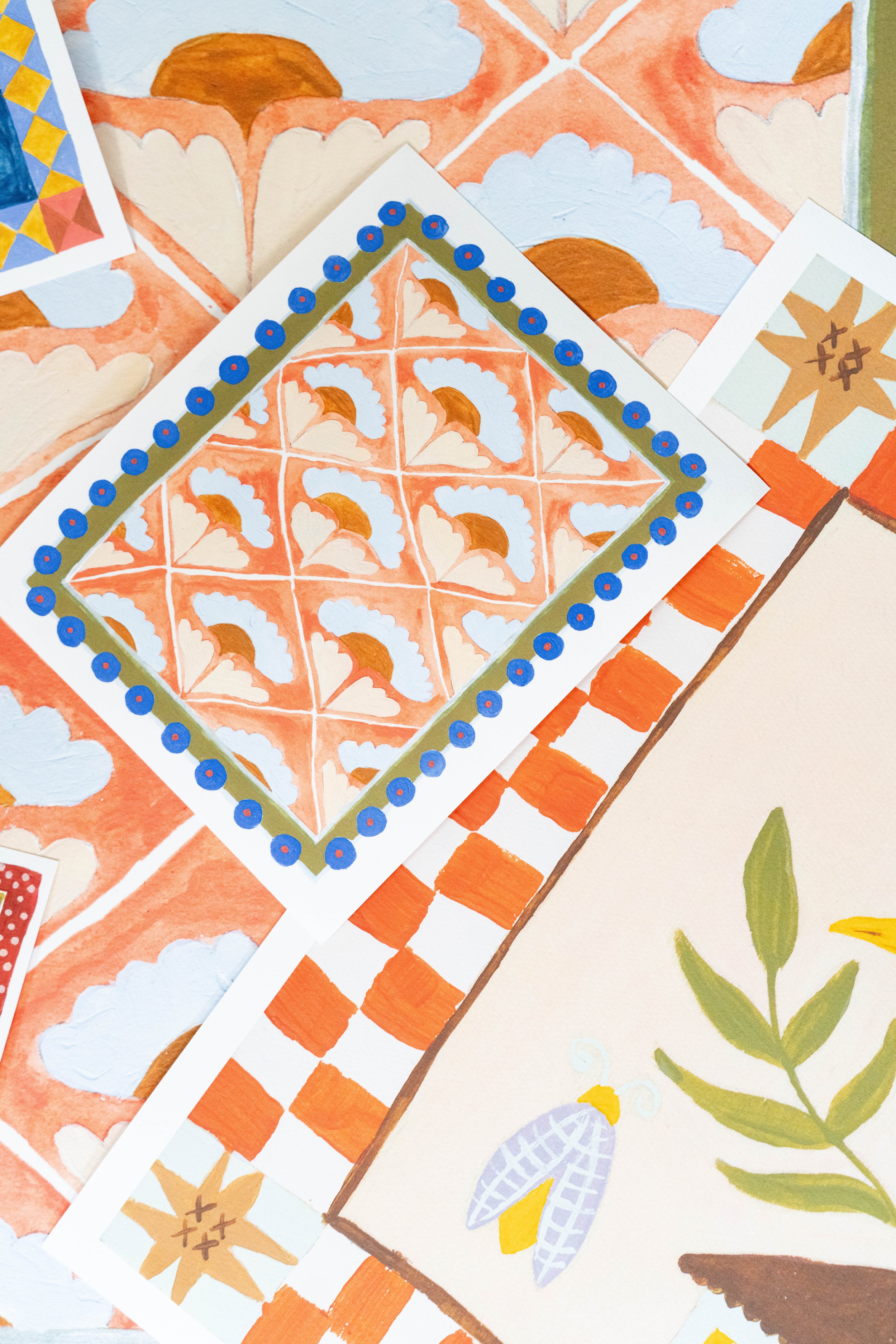 Handmade illustrations and patterns, including an orange diamond-shaped tile pattern with white and brown details, a grid of orange squares, a beige background with a green plant and yellow and gray insect, and a partially visible colorful geometric