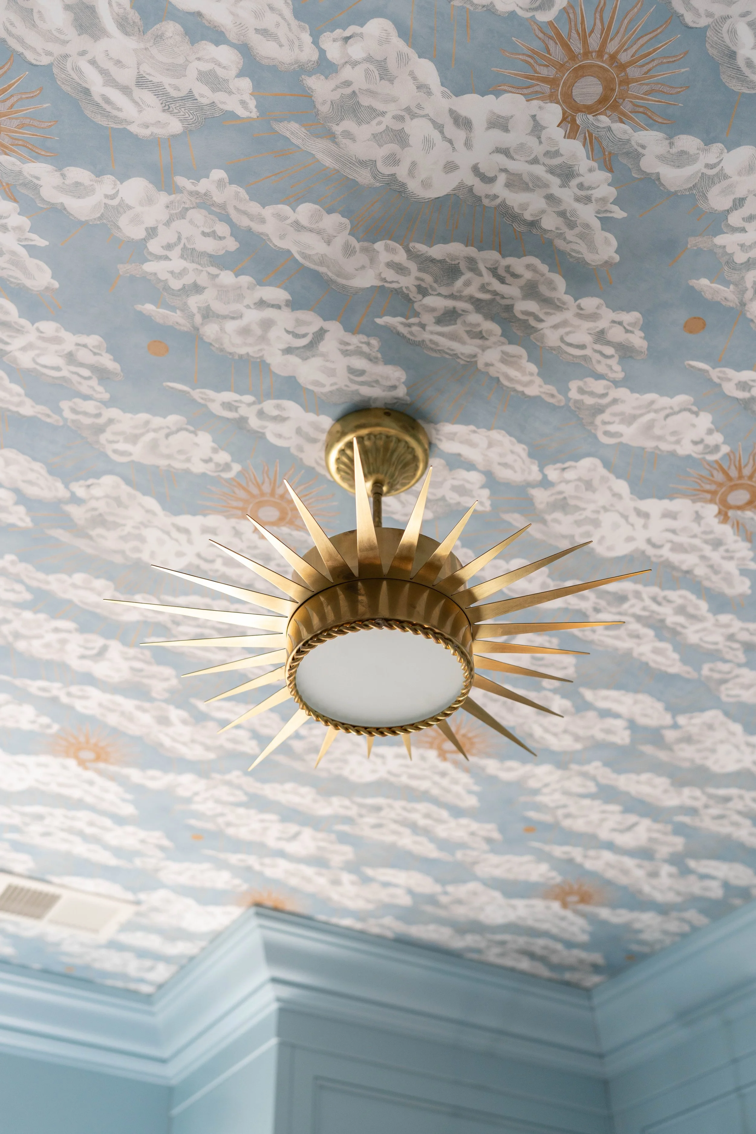 Decorative ceiling with clouds and sunshine pattern, gold starburst ceiling light fixture.