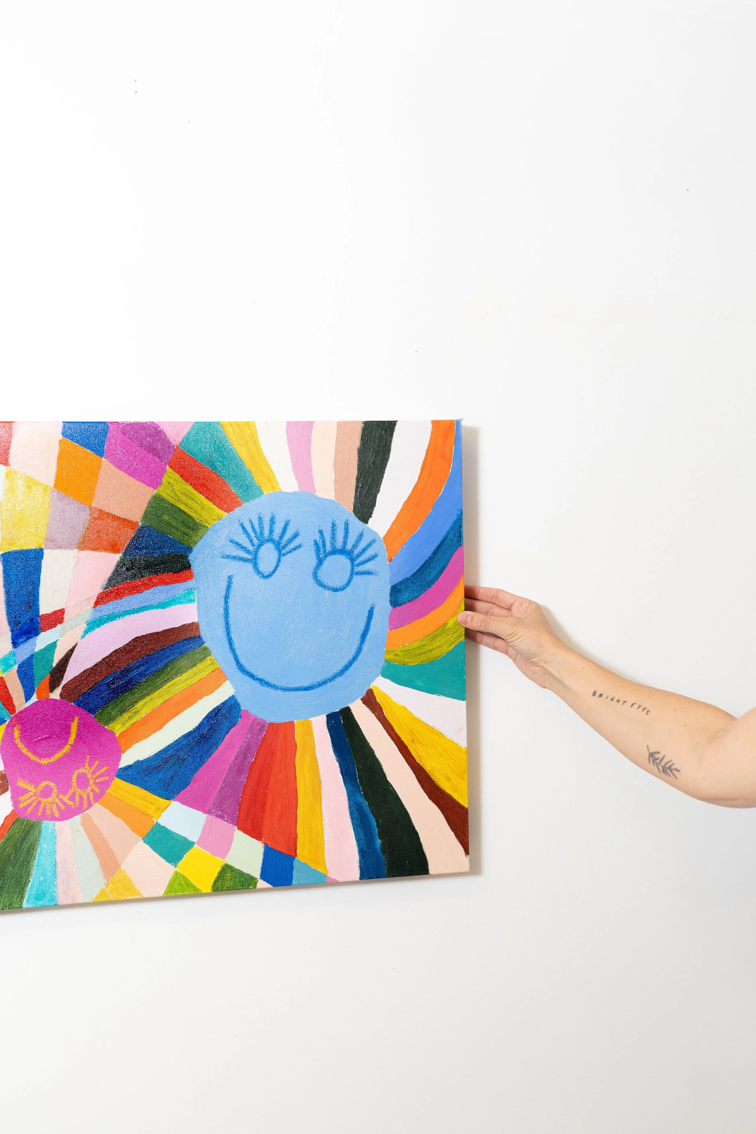Artist product photography by Chandler Cox — tattooed hand holding colorful abstract painting against white background, Columbia SC artist and creative product photographer