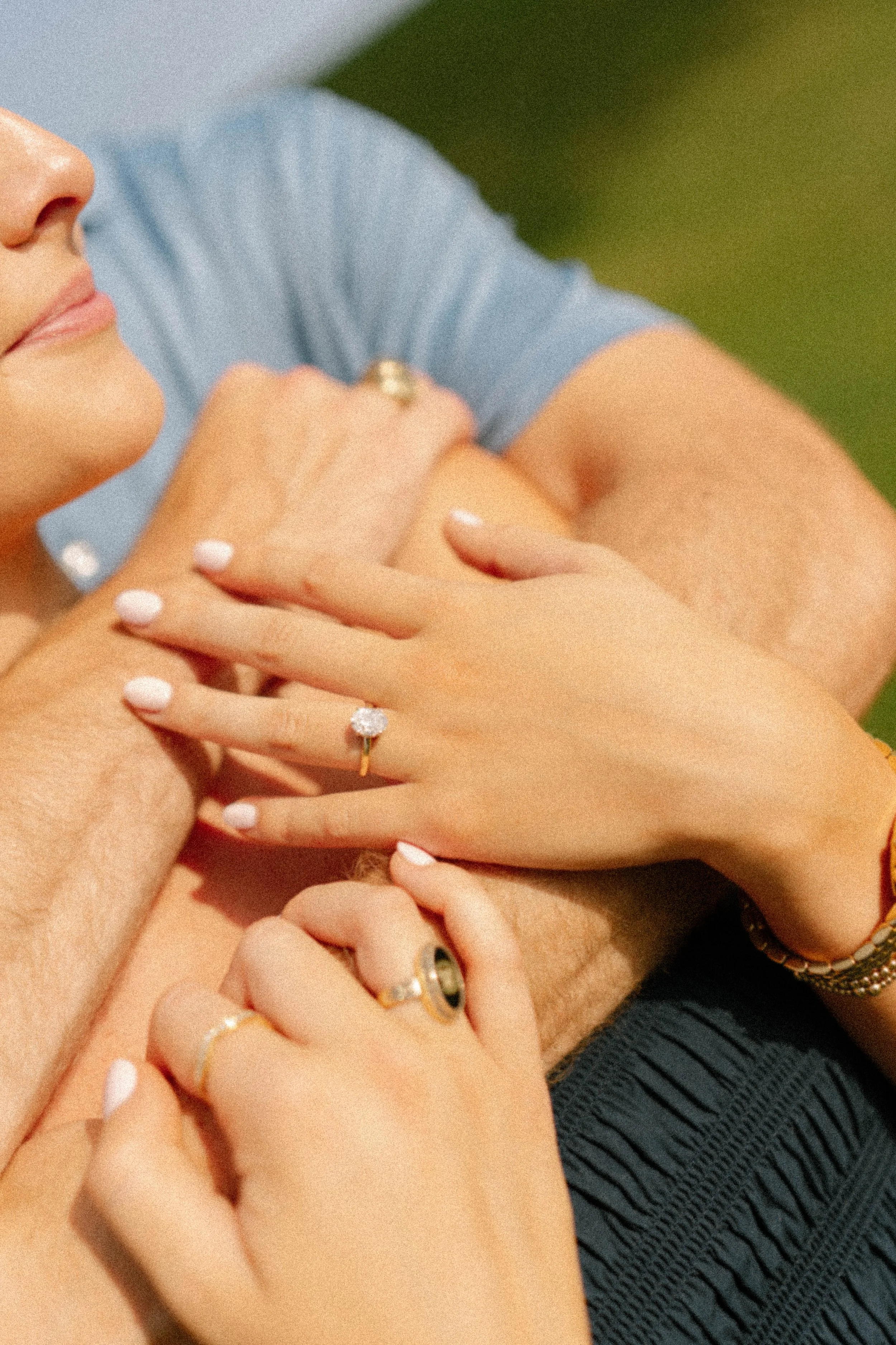 Engagement ring detail photography by Chandler Cox — couple's intertwined hands showing diamond engagement ring and wedding band outdoors, Columbia SC wedding and jewelry photographer