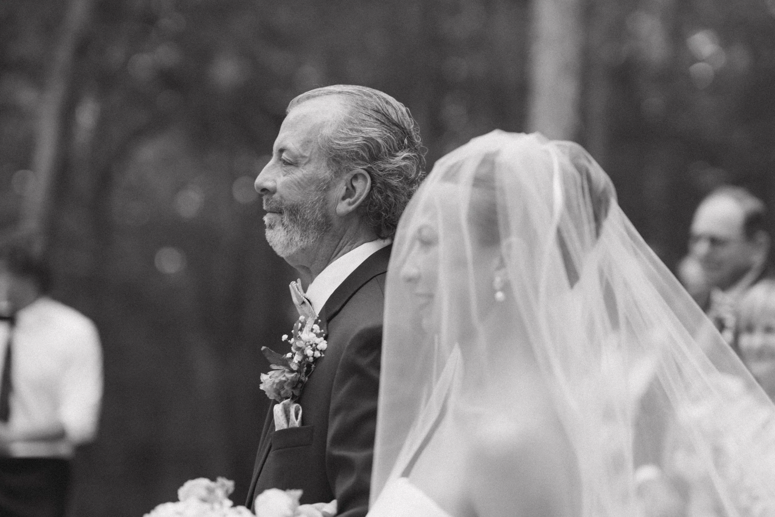 Black and white image of father and daughter walking down isle together in wedding ceremony in South Carolina