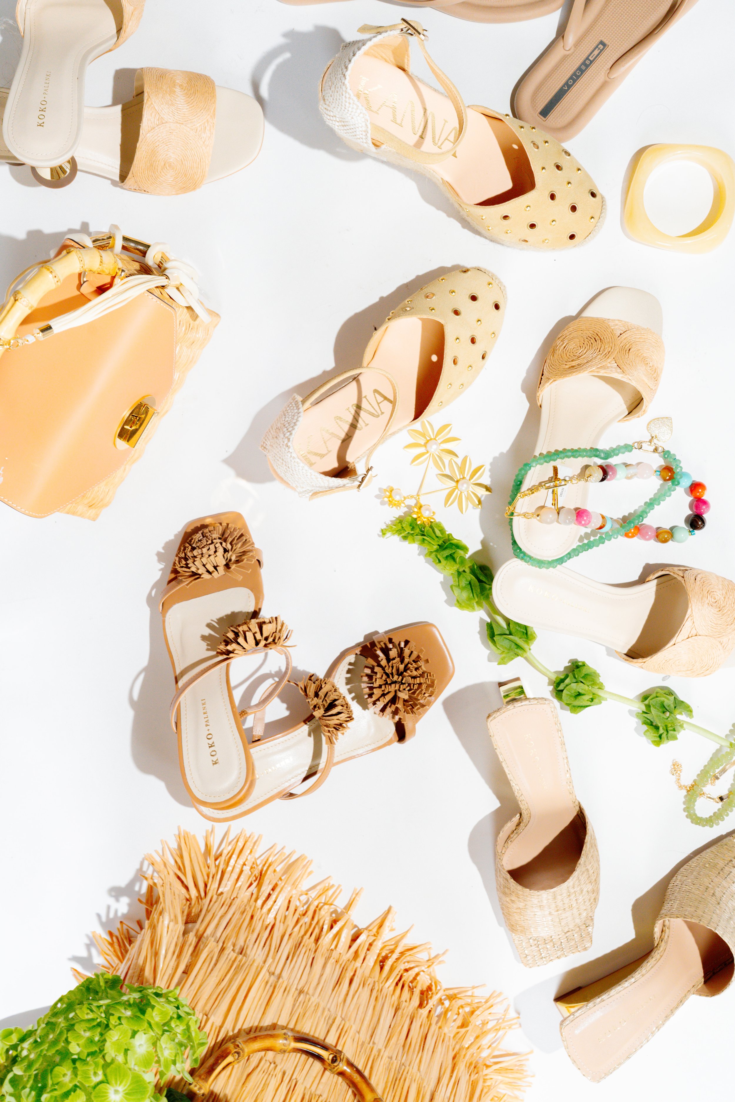 Styled flat lay product photography by Chandler Cox — summer accessories including sandals, handbags, and jewelry arranged on white background, Columbia SC commercial photographer