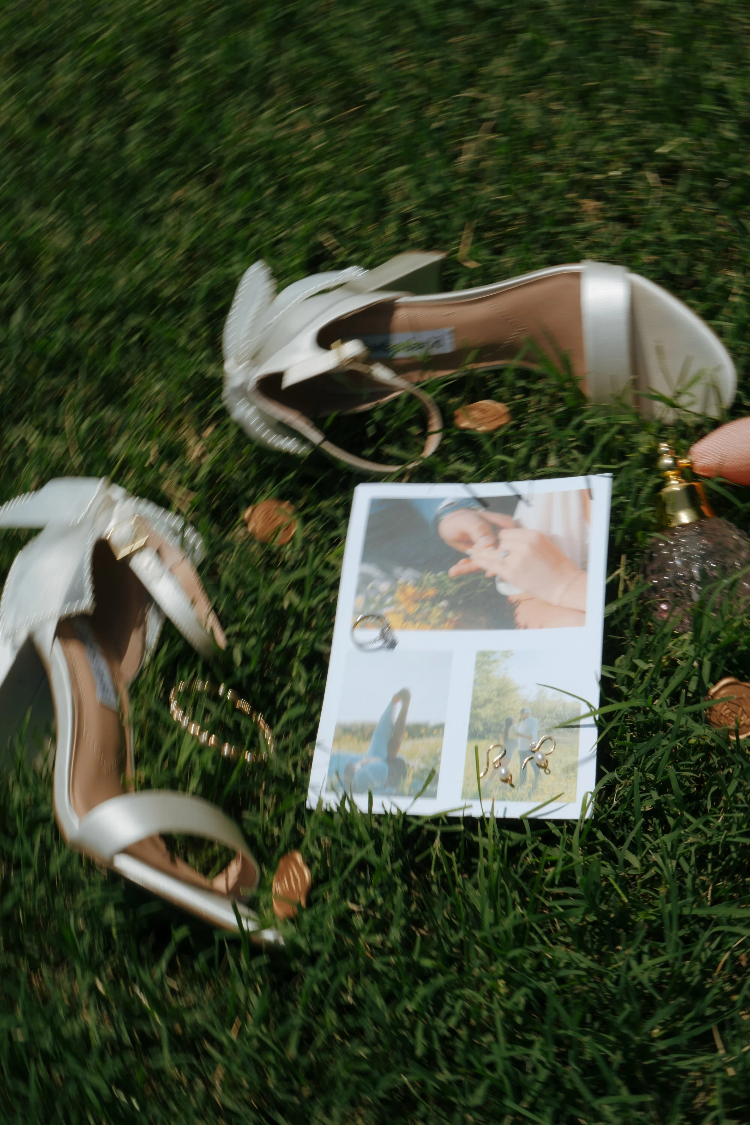 A beige high-heeled sandal shoe, a pair of earrings, and a photo booth picture of a person holding flowers on grass.