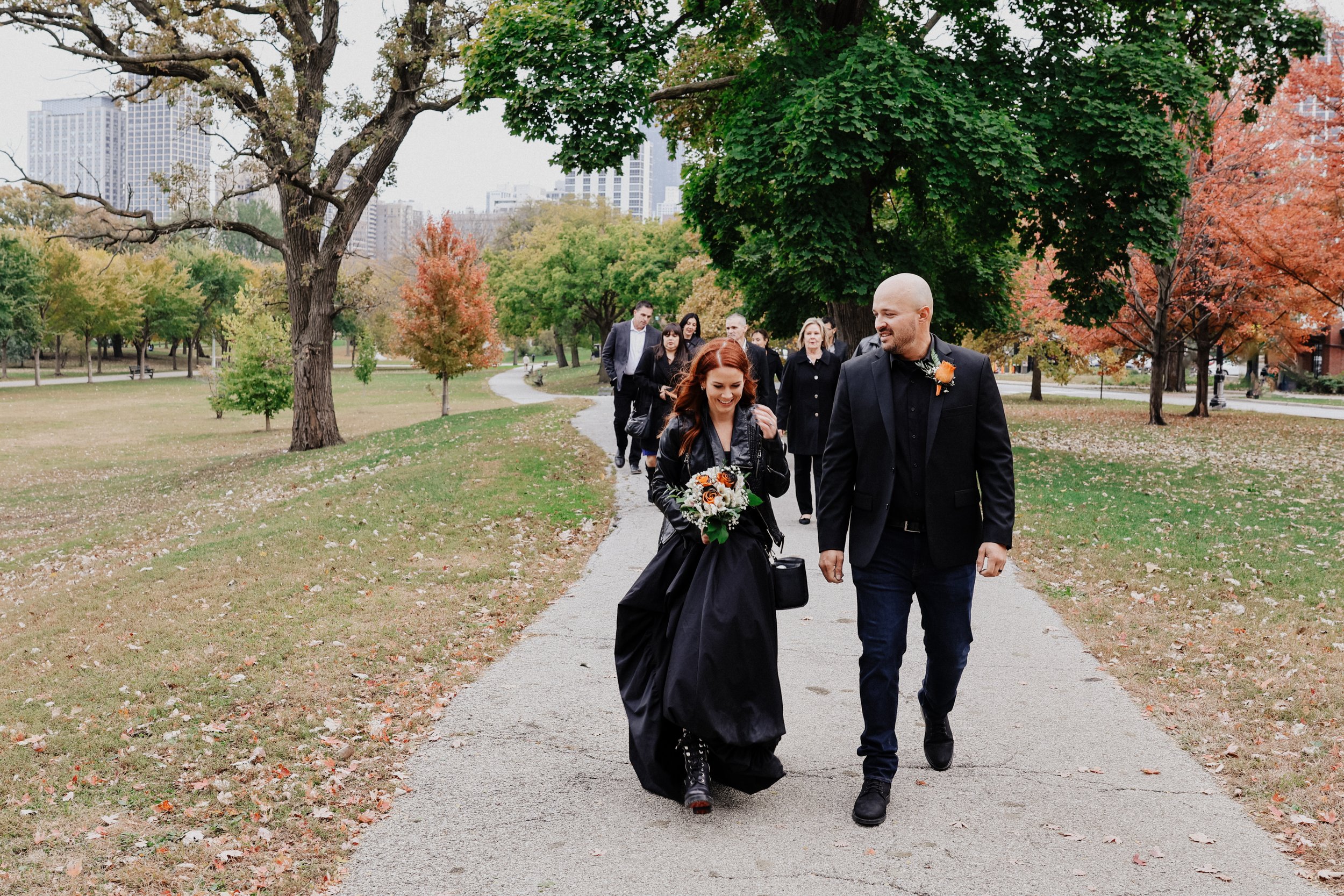 A married couple walks with family in Lincoln Park, Chicago, IL for wedding photos.