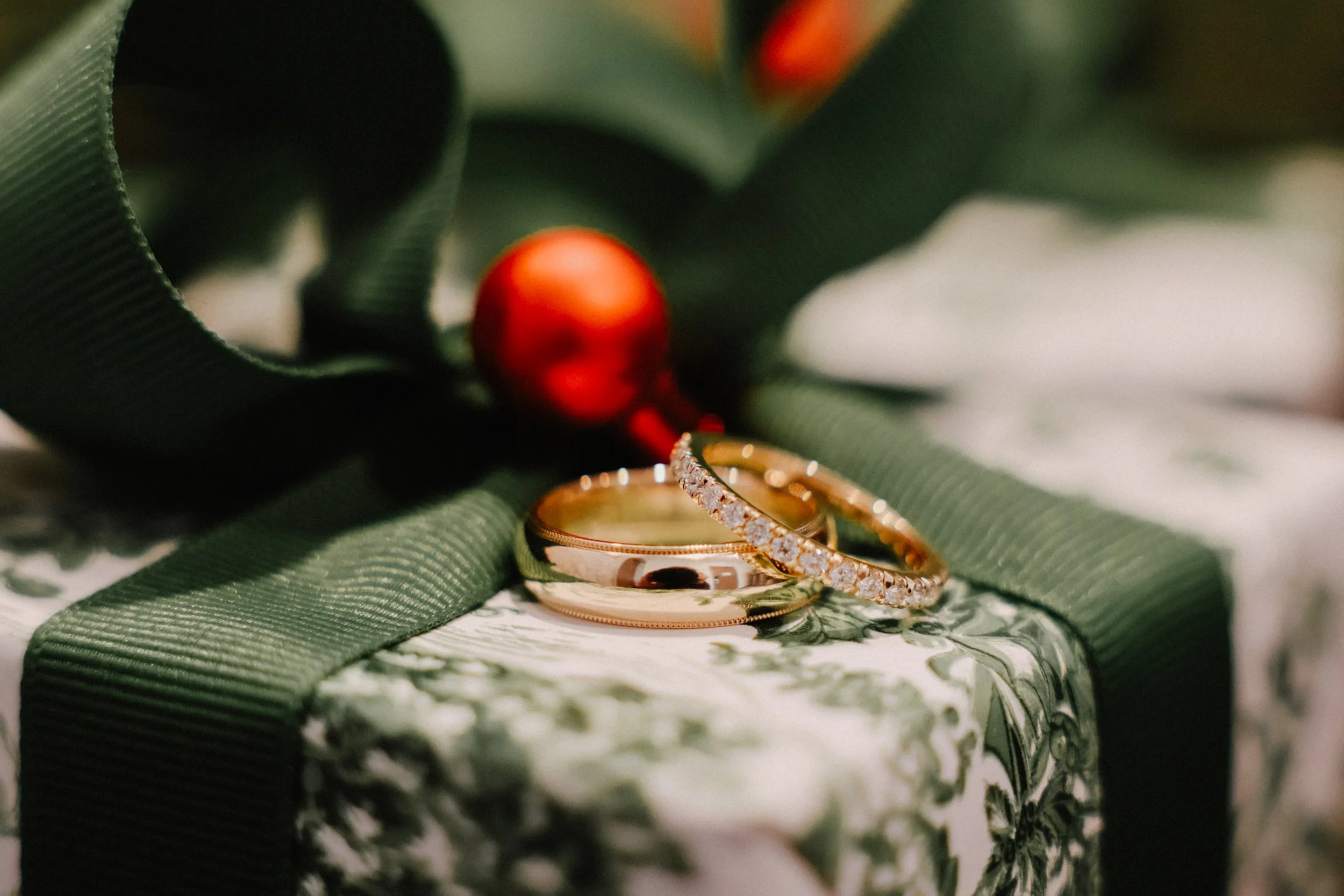 Wedding bands atop a Christmas package.