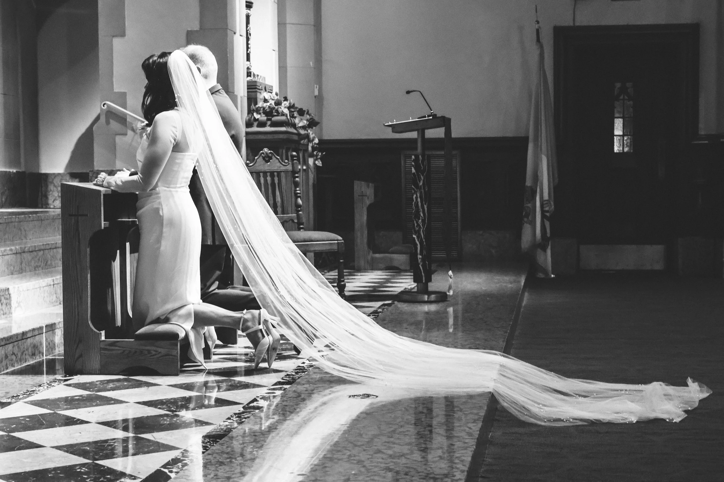 A couple kneels at the altar during a wedding ceremony at Saint Francis Xavier Parish in Wilmette, IL.