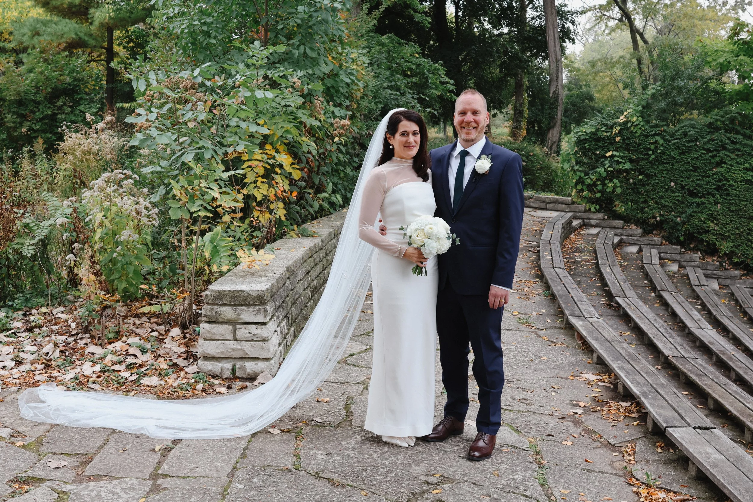A bridge and groom pose for portraits in a park near Wilmette Harbor Club outside of Chicago, IL.