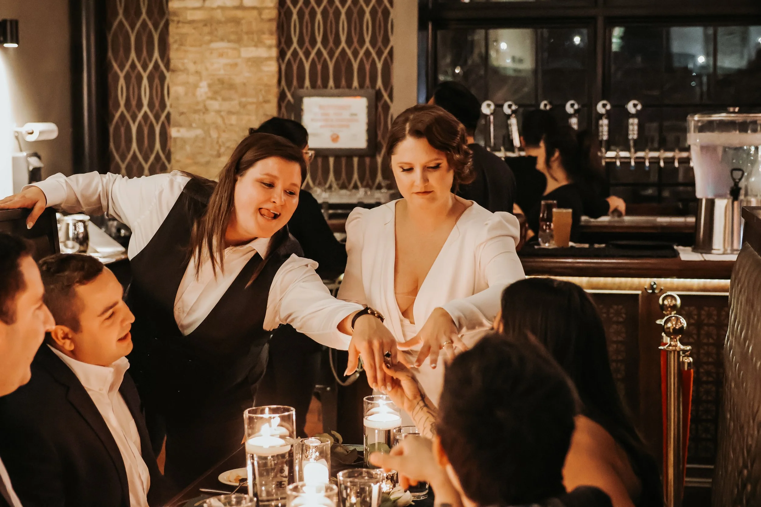 Two brides share their rings with friends at Eris Brewery and Cider House in Chicago, IL.