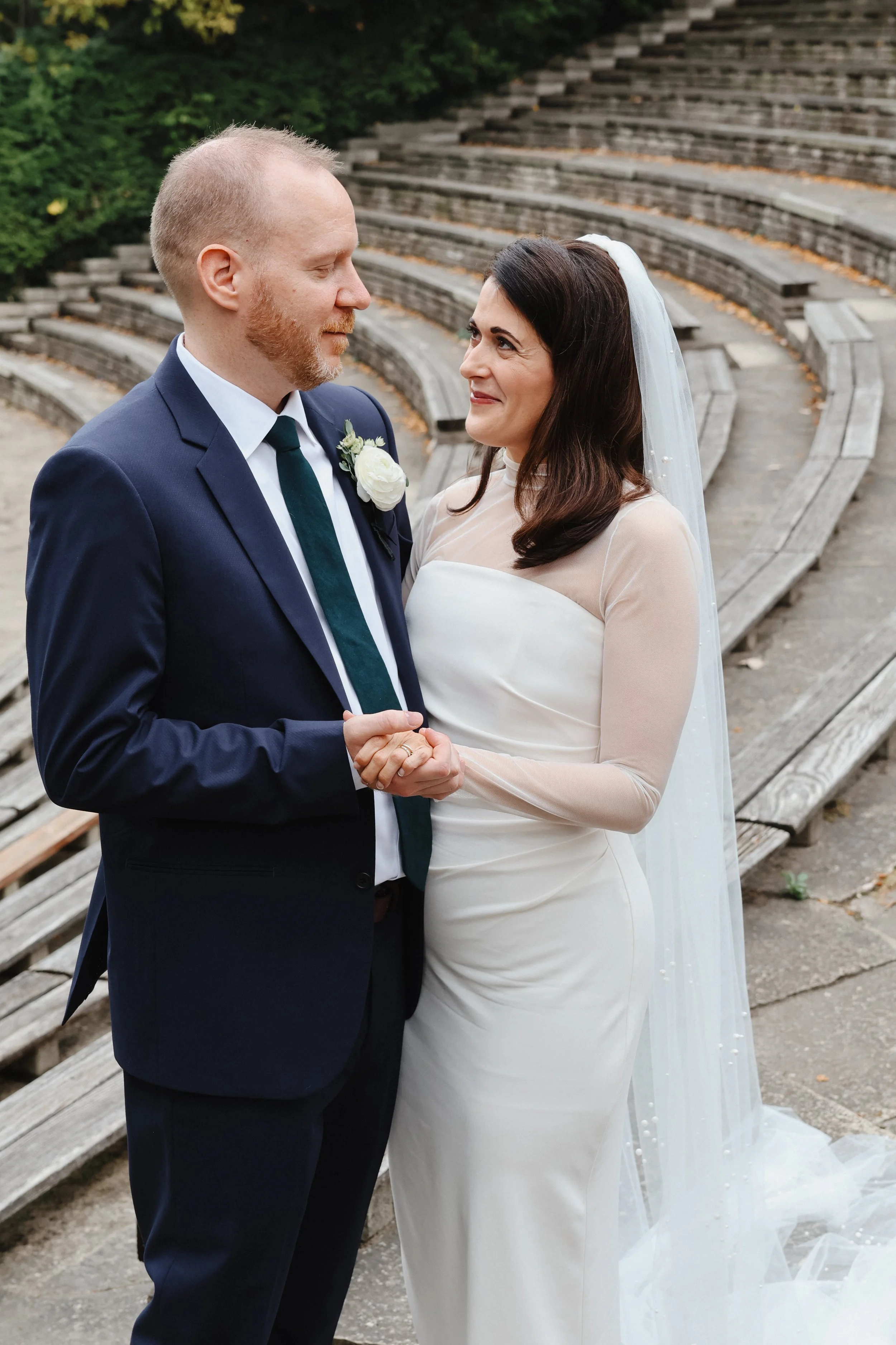 A married couple gazes at one another in a park near Wilmette Harbor Club.