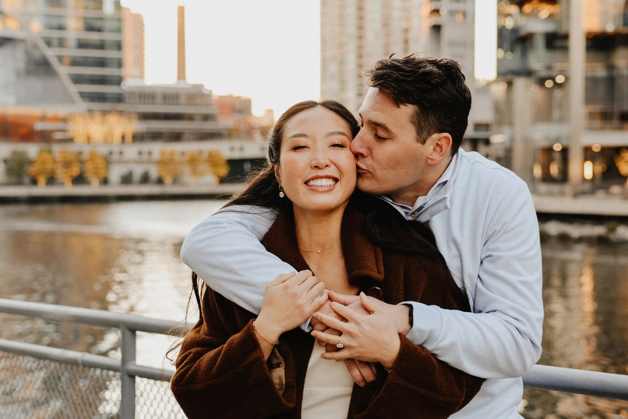 A groom kisses his bride-to-be on the cheek in River North Chicago.