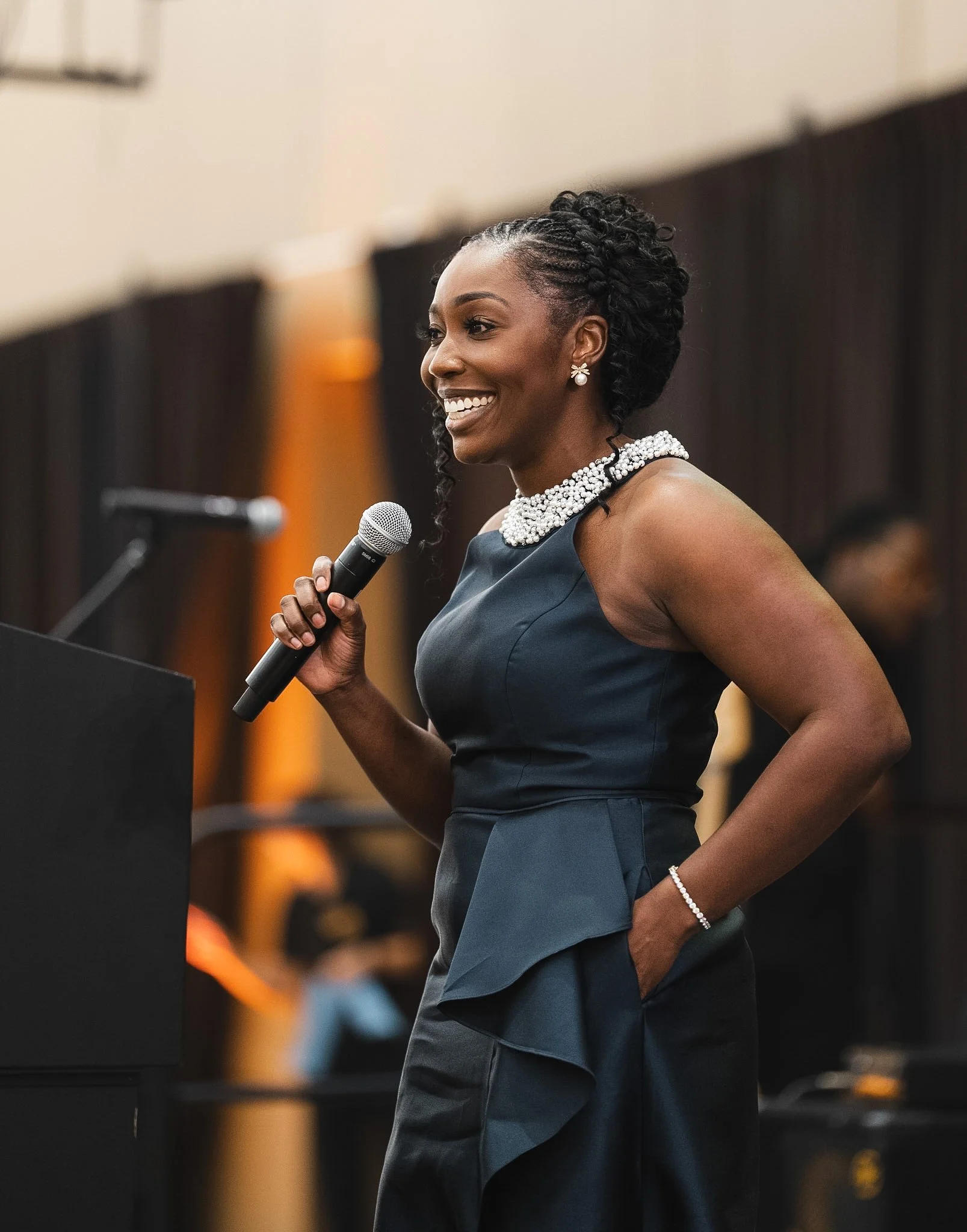 Alicia Hill speaking with a microphone at a podium