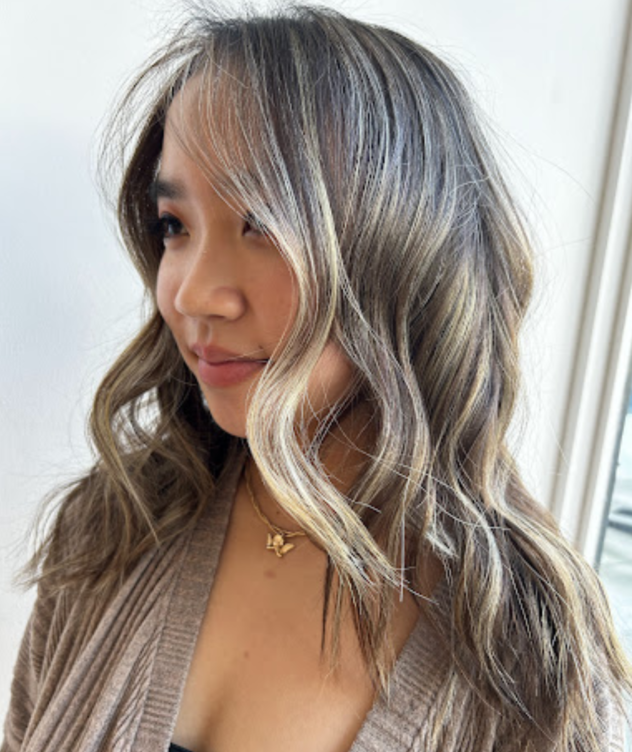 Cool-toned blonde foilayage with brightened money-piece highlights on shoulder-length hair.
