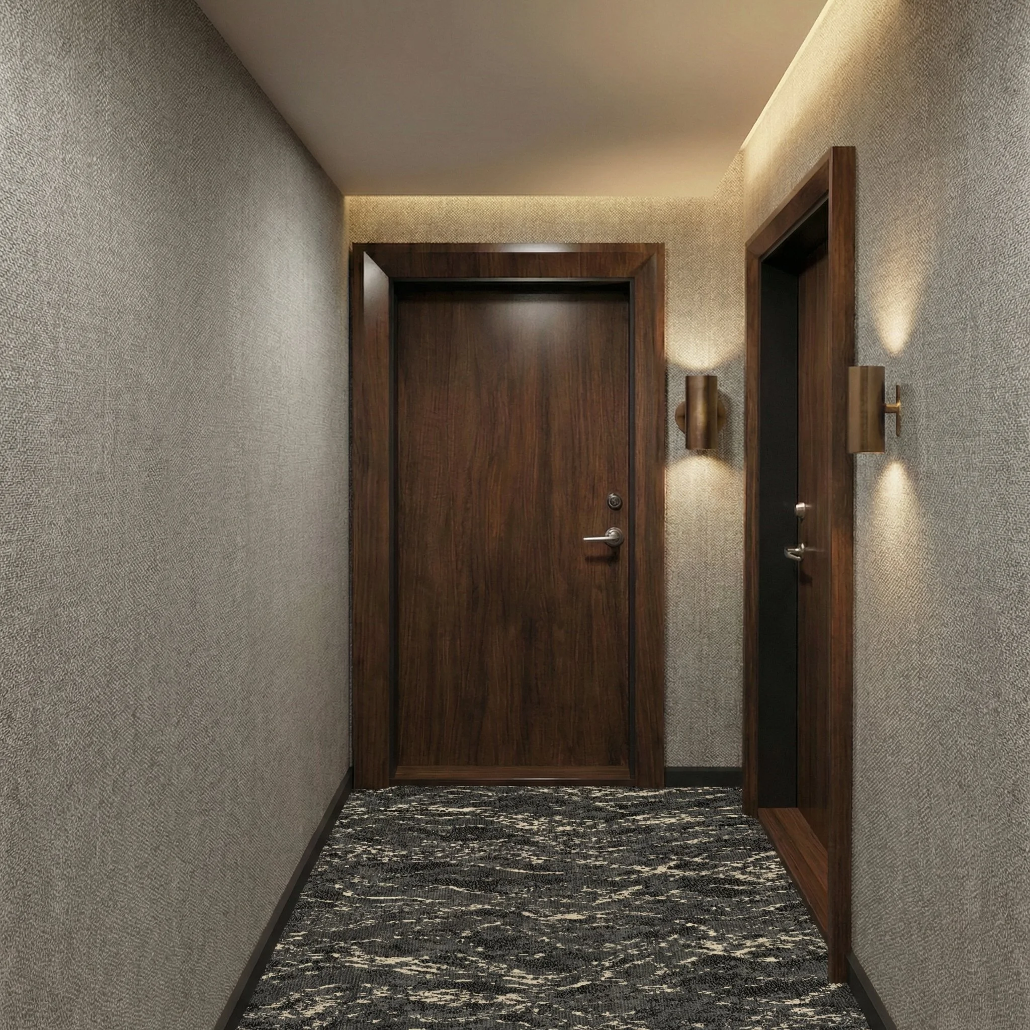 A hotel hallway with a closed wooden door, illuminated wall sconces, and patterned carpet.