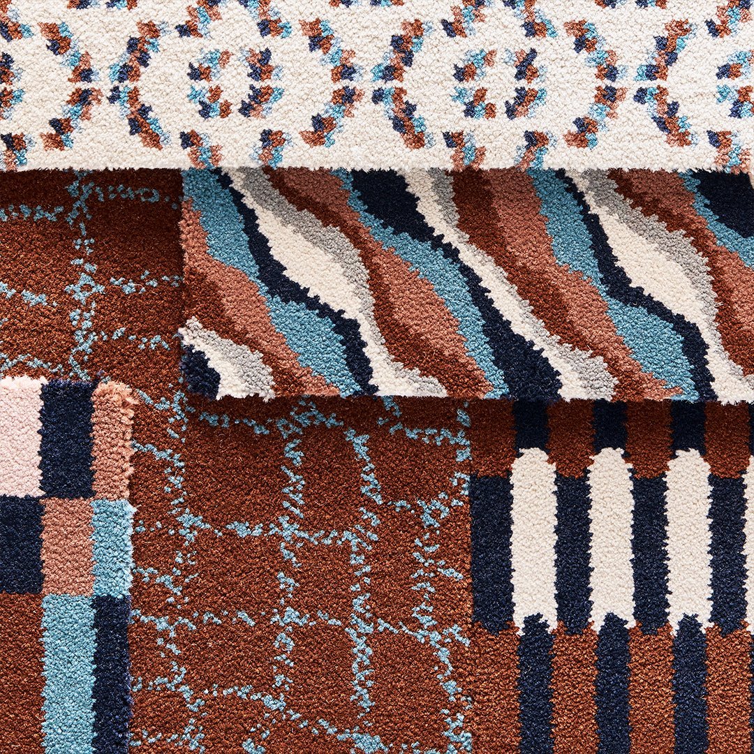 Close-up of a patterned rug with geometric and floral designs in shades of brown, blue, black, and white.