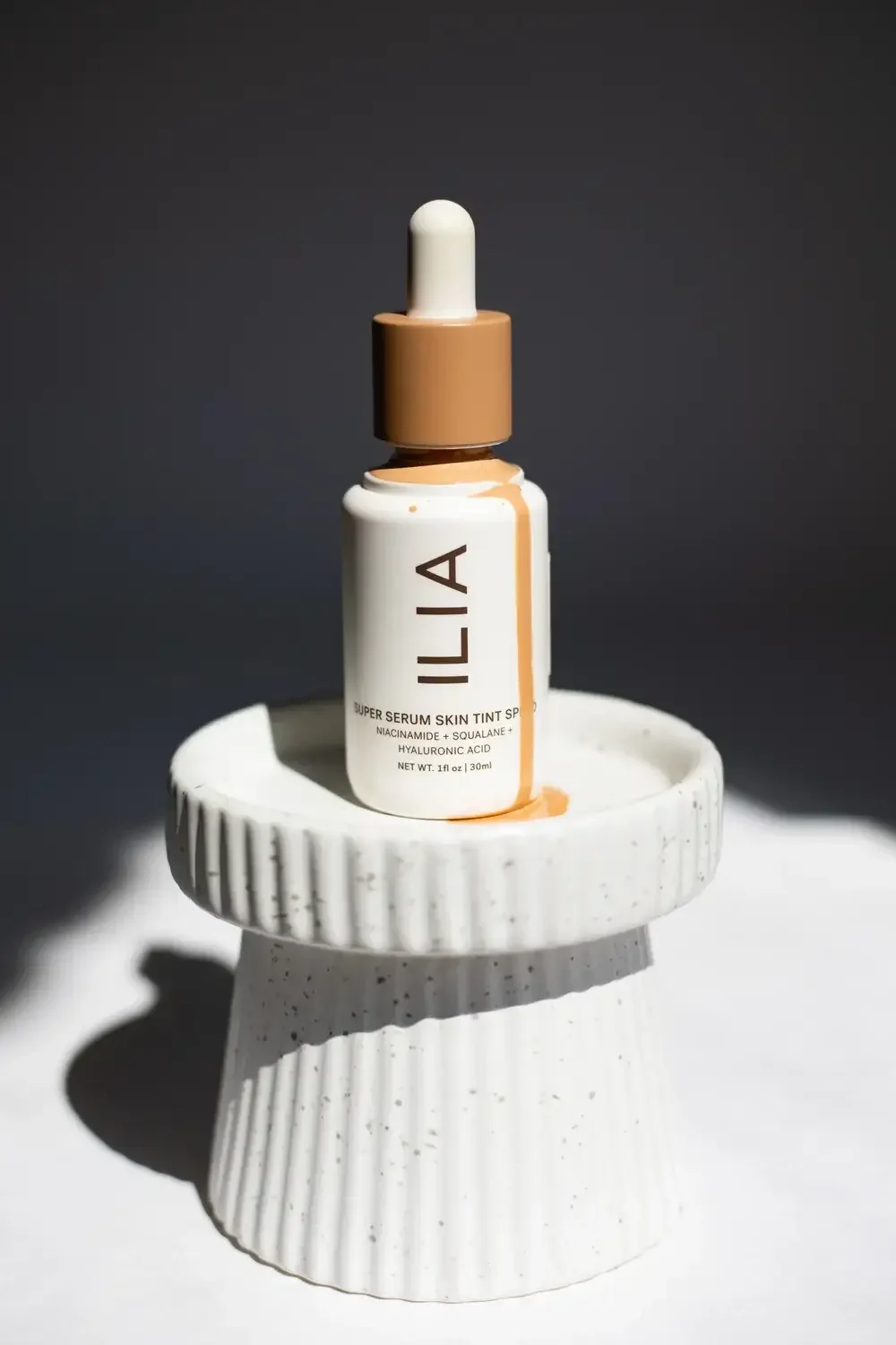 Lila foundation oil poured into a small white bowl, showcasing its smooth texture and rich color.

