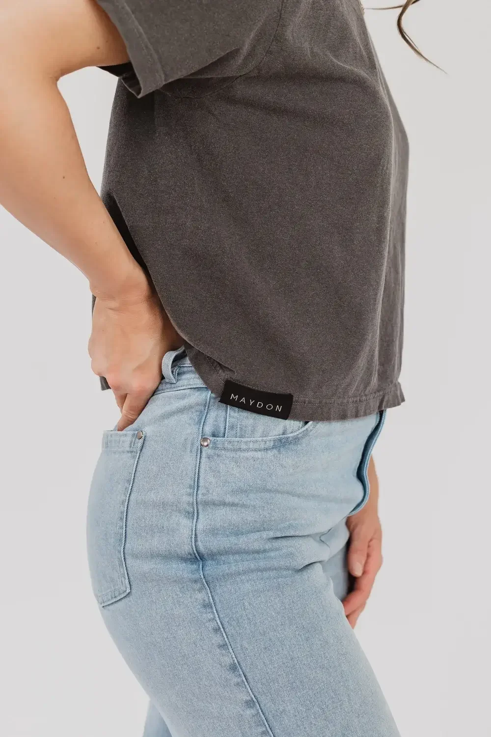 Back view of a woman wearing a grey t-shirt, showcasing a casual and relaxed style.
