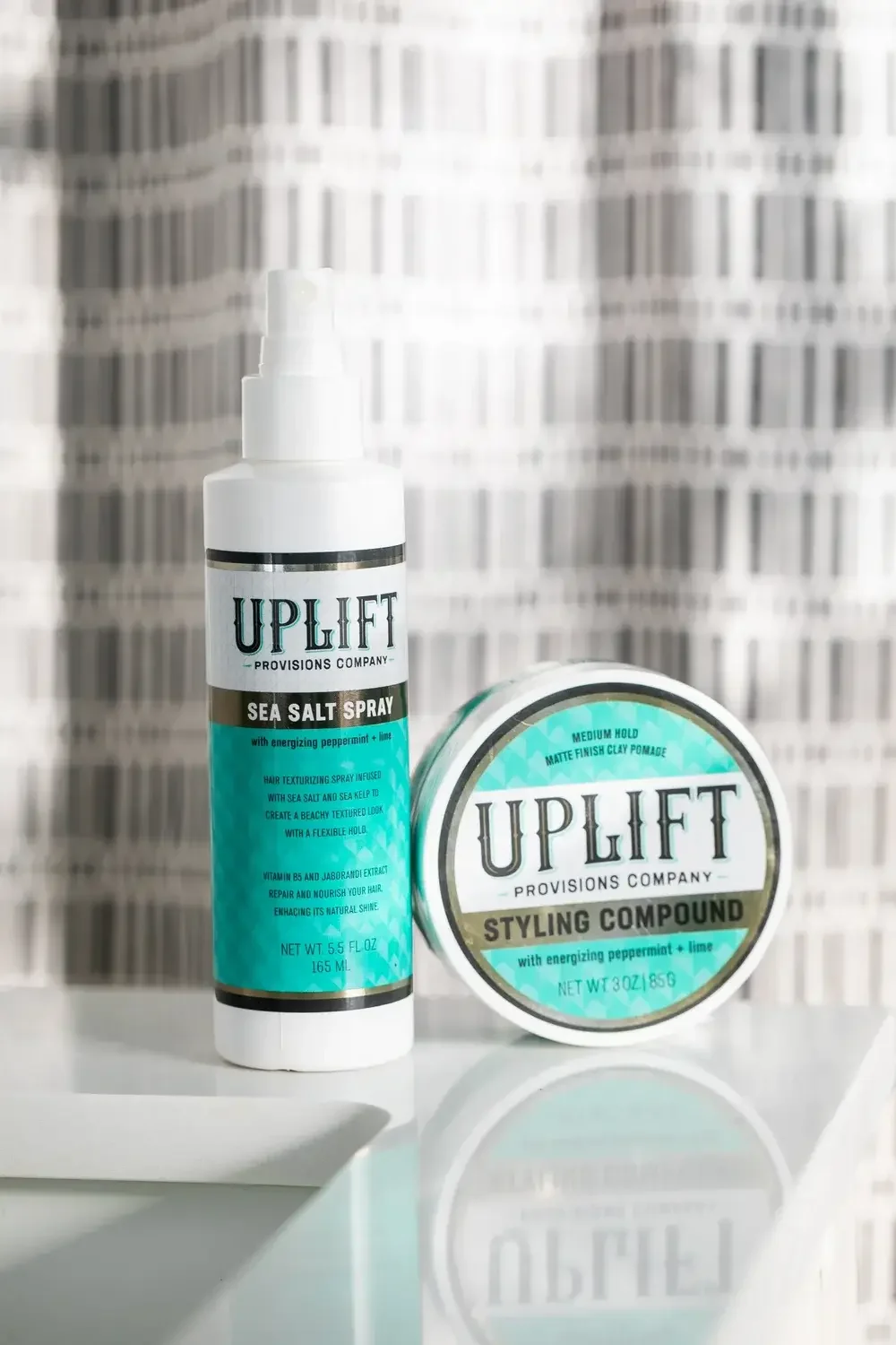 Uplift styling gel and spray displayed together on a white background, showcasing their sleek packaging and branding.