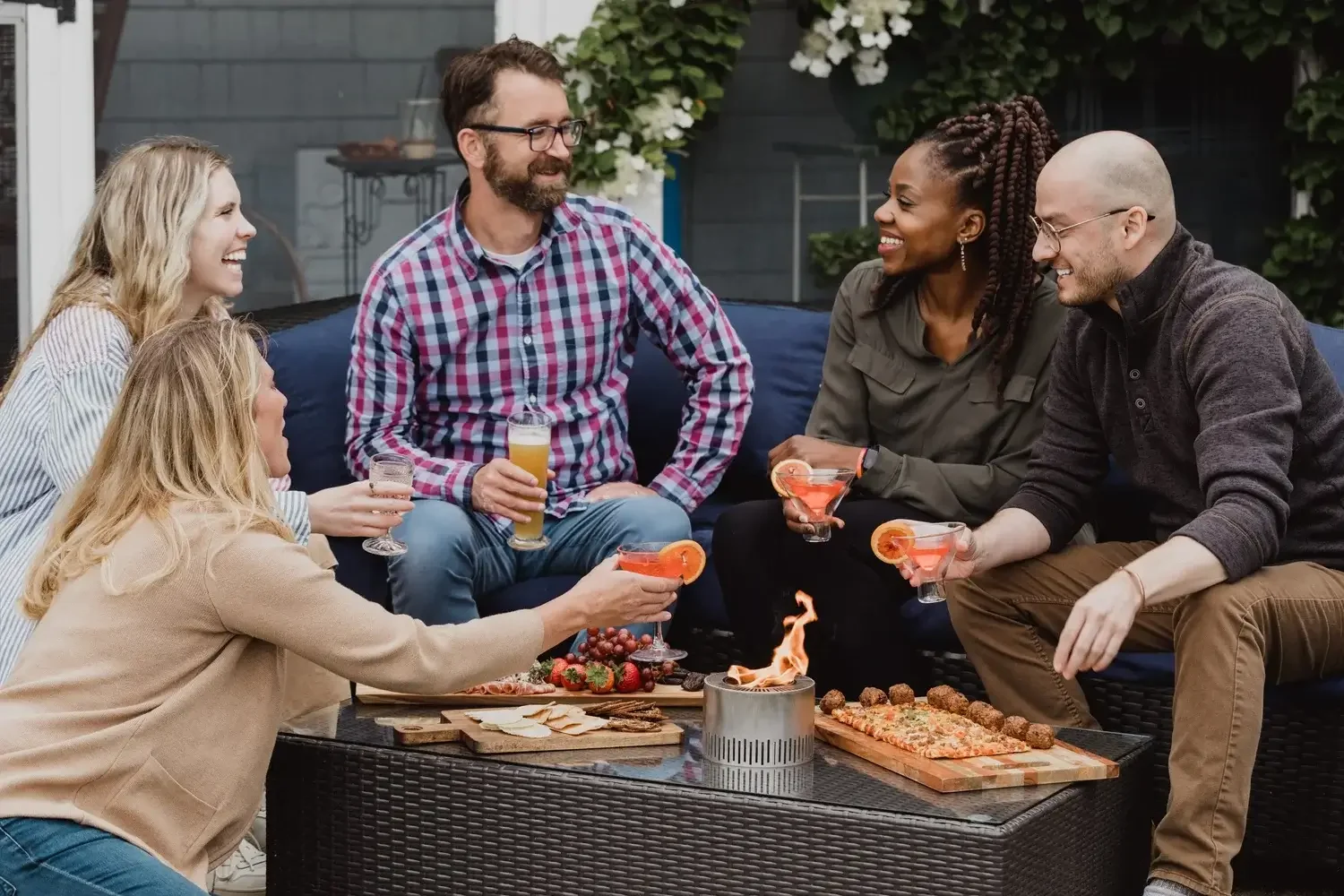 A group of friends gathered around a fire pit, sharing laughter and warmth on a cozy evening outdoors.
