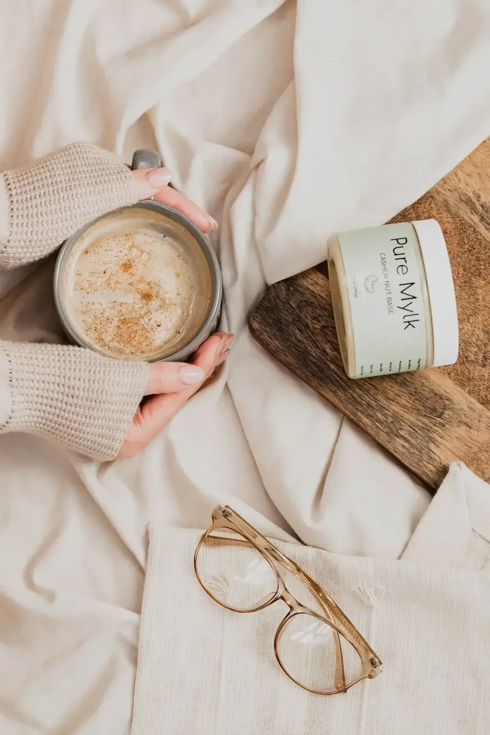  A person holding a cup of coffee in one hand and a mug of milk in the other, showcasing a cozy beverage moment.