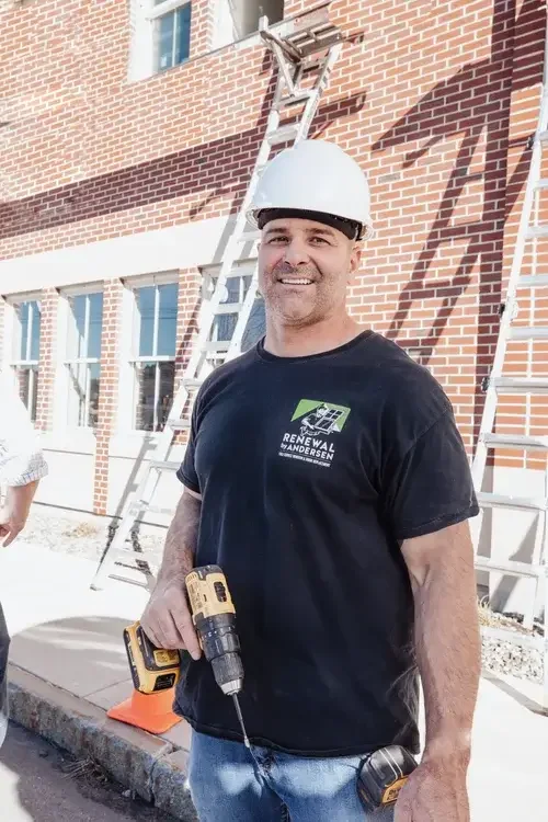  Two men in hard hats stand beside a construction site, discussing plans near a partially built building.