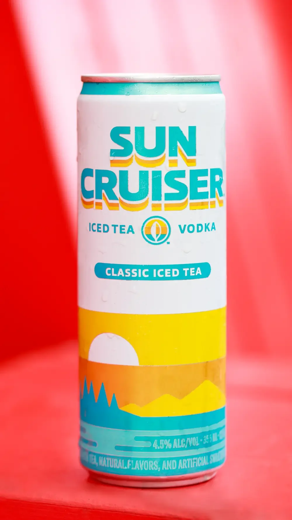  A can of Sun Cruiser iced tea rests on a red chair, showcasing its vibrant design against the chair's color.