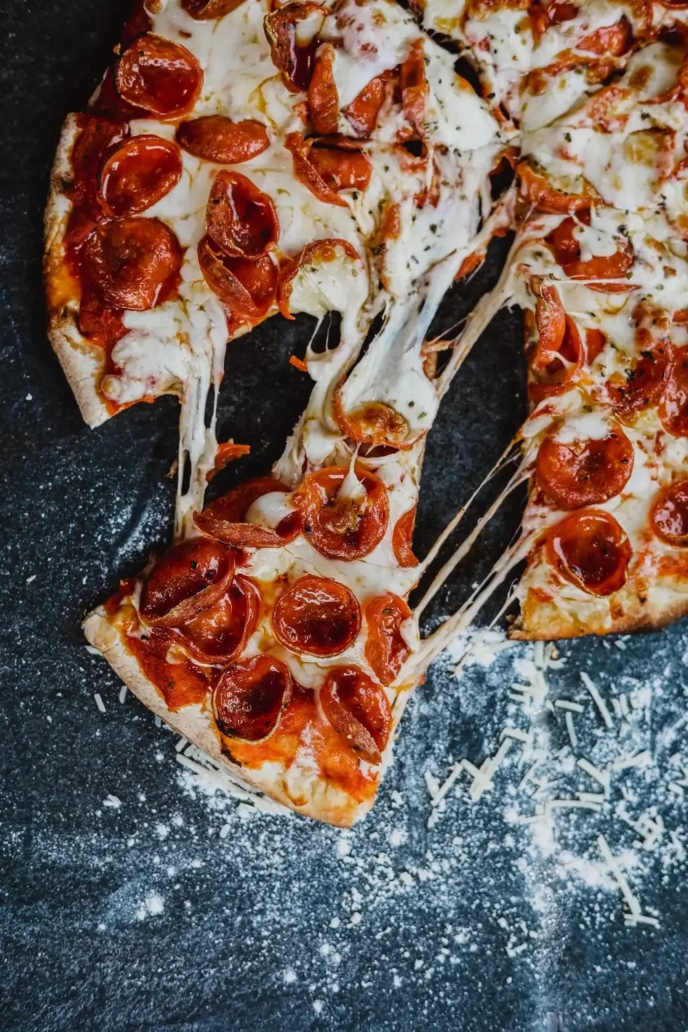 A pepperoni pizza with a single slice removed, showcasing melted cheese and pepperoni toppings.
