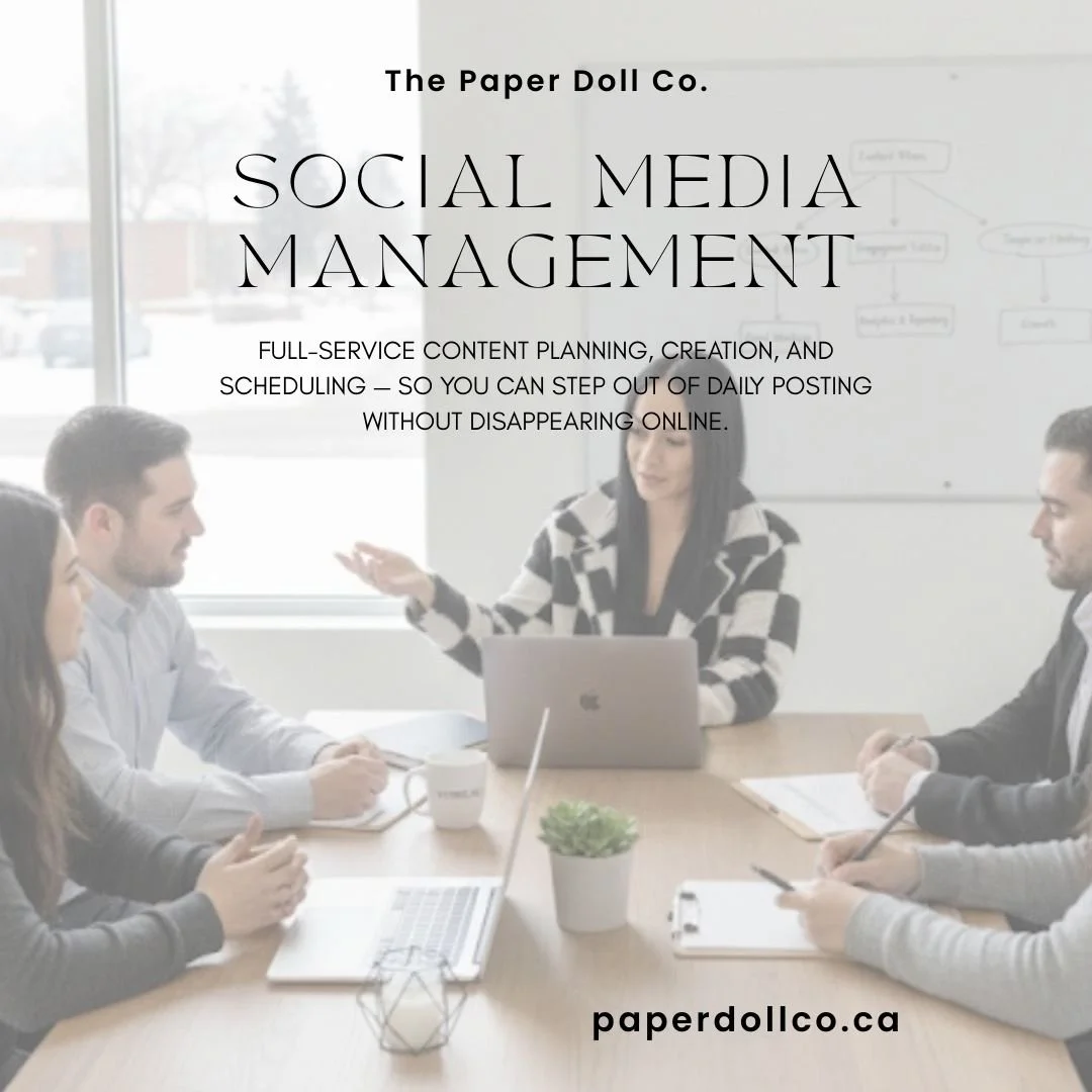 A group of five people in an office meeting, with laptops and notebooks on the table, and a whiteboard in the background.