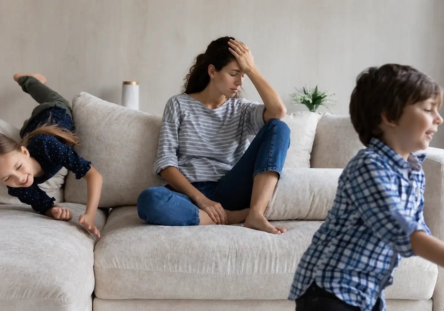 Overwhelmed mother sitting with her children during the school holidays, illustrating the mental load and emotional exhaustion discussed by Townsville Counselling & Wellness.