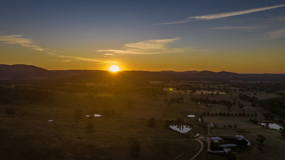 Sunset over rural landscape with trees and ponds