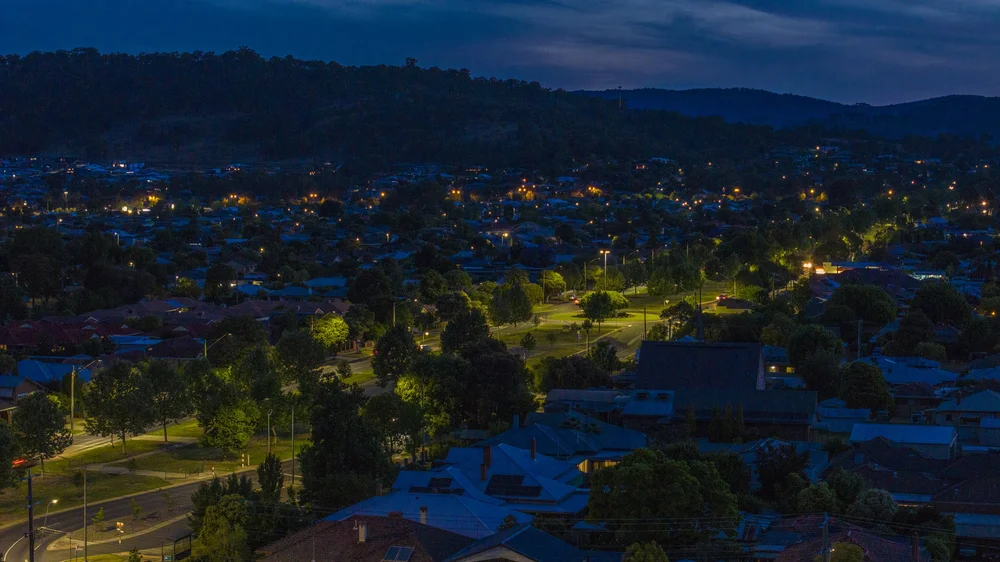 Nighttime cityscape with streetlights and houses