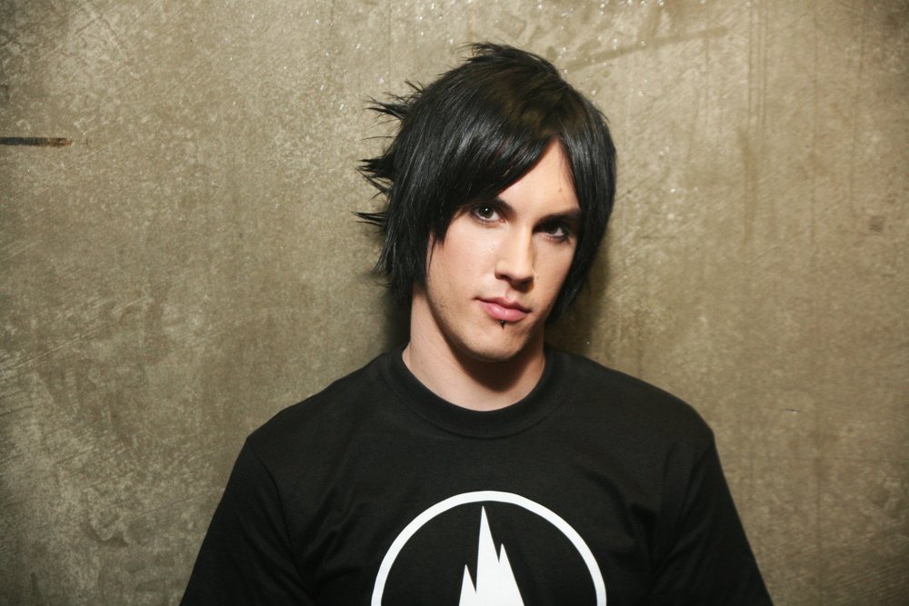 Person with black hair and lip ring in front of plain background.
