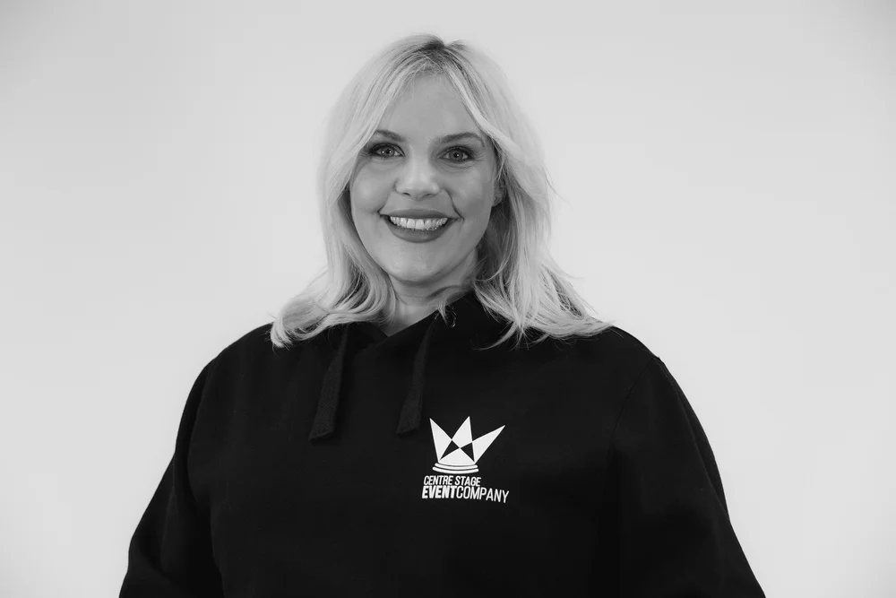 Woman smiling wearing black "Centre Stage Event Company" sweatshirt.