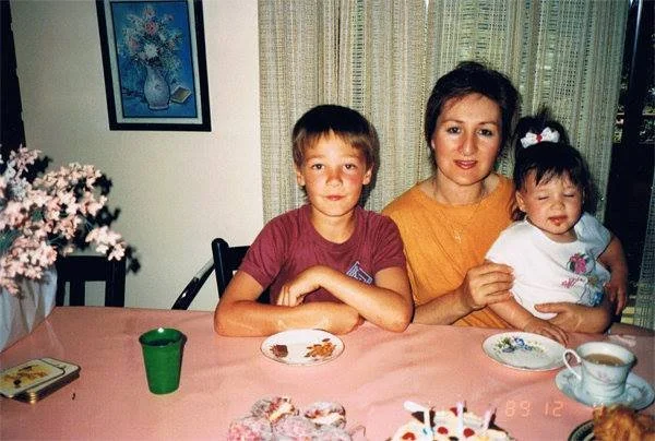 Amos as a child, sitting with his mother and sister at a table